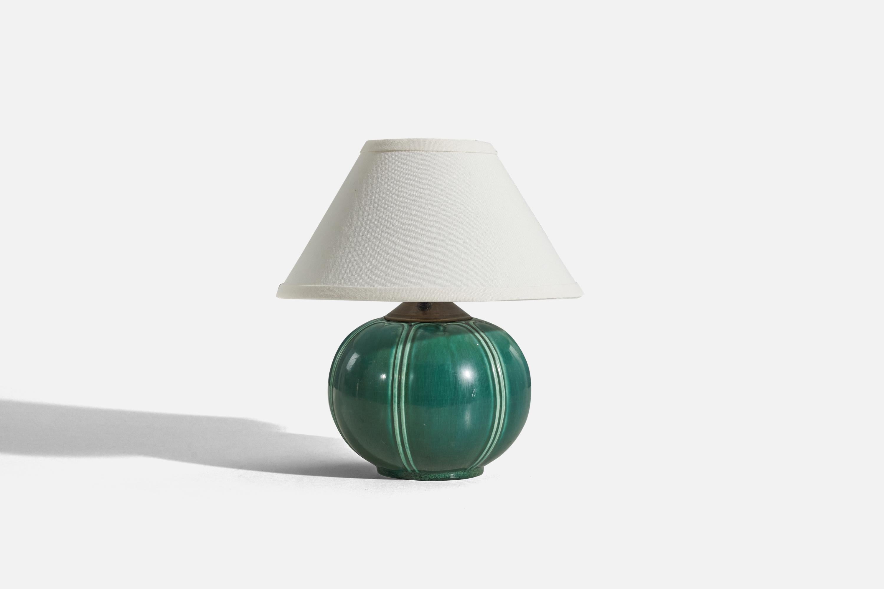 A green-glazed earthenware and brass table lamp designed and produced by Upsala-Ekeby, Sweden, 1930s.

Sold without lampshade. 
Dimensions of lamp (inches) : 8.25 x 6.5 x 6.5 (H x W x D)
Dimensions of shade (inches) : 4.5 x 10.25 x 6.125 (T x B