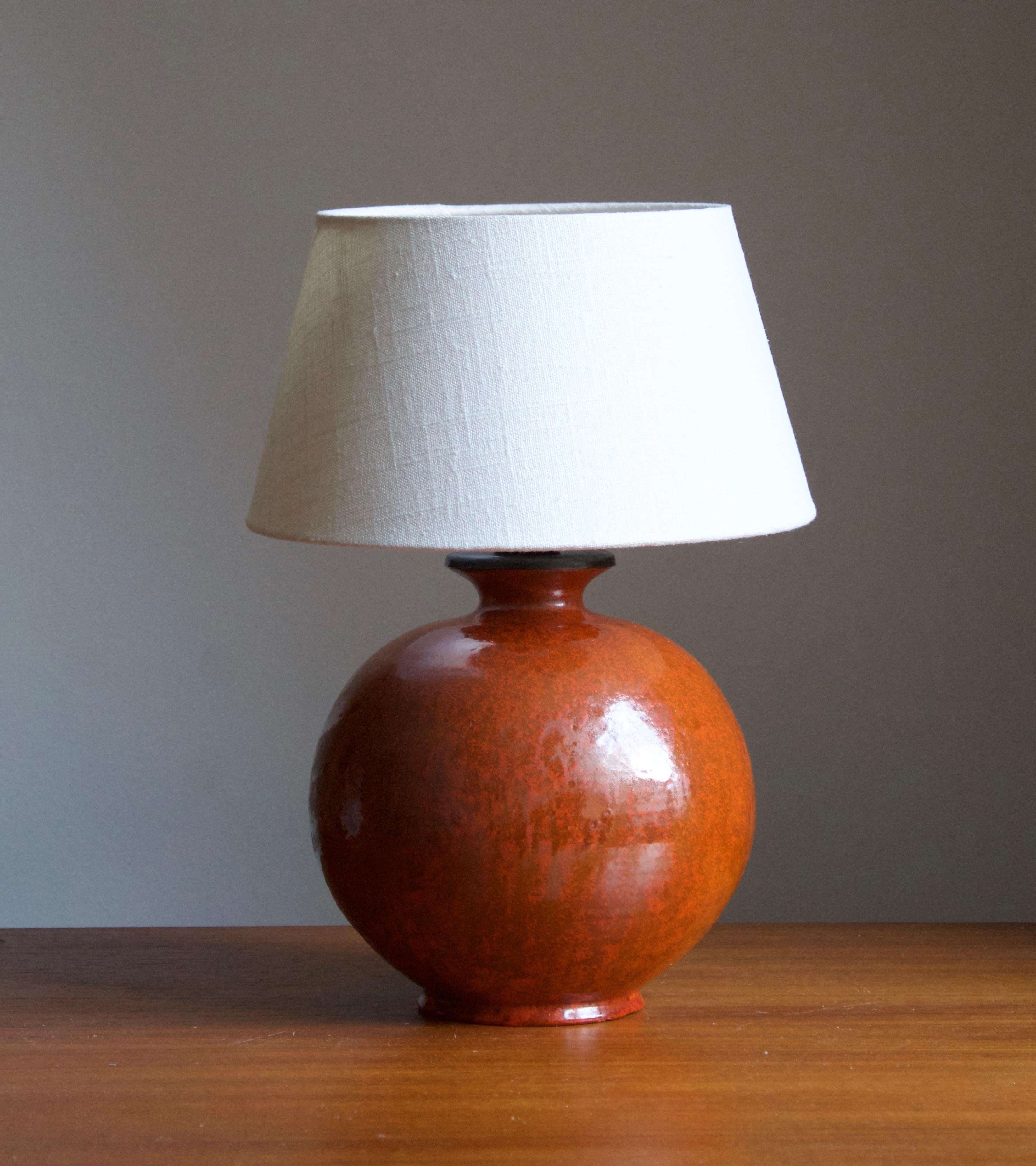 An early modernist table lamp. by Upsala-Ekeby, Sweden, 1930s. Stamped. 

Stated dimensions exclude lampshade. Height includes the socket. Sold without lampshade.

Glaze features an orange color.

Other designers of the period include Ettore