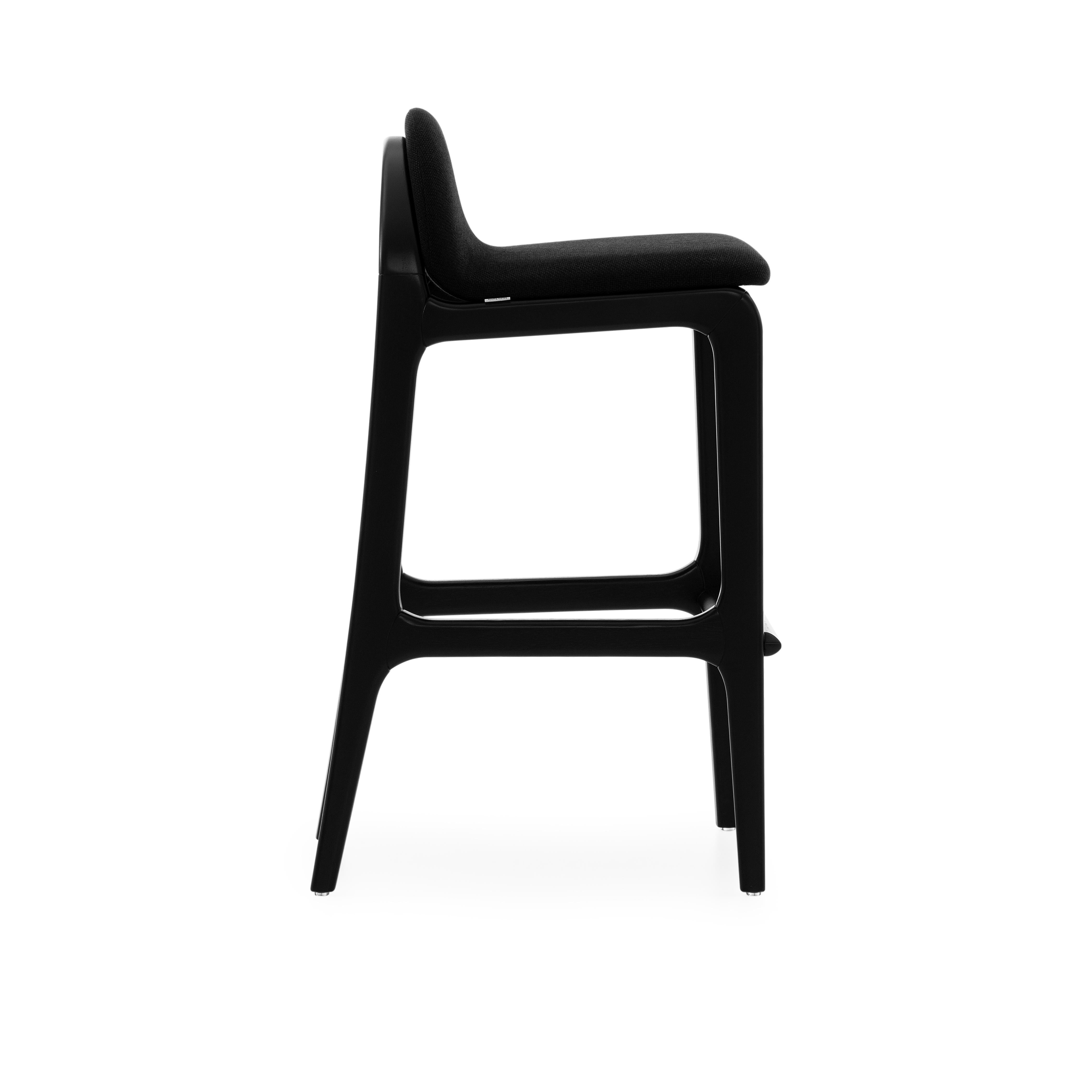 This beautiful Ura bar stool in a black wood base and an upholstered black fabric seat made in Brazil by our team of architects and designers from Uultis Design studio was fabricated with environmentally sustainable materials. It is designed with a