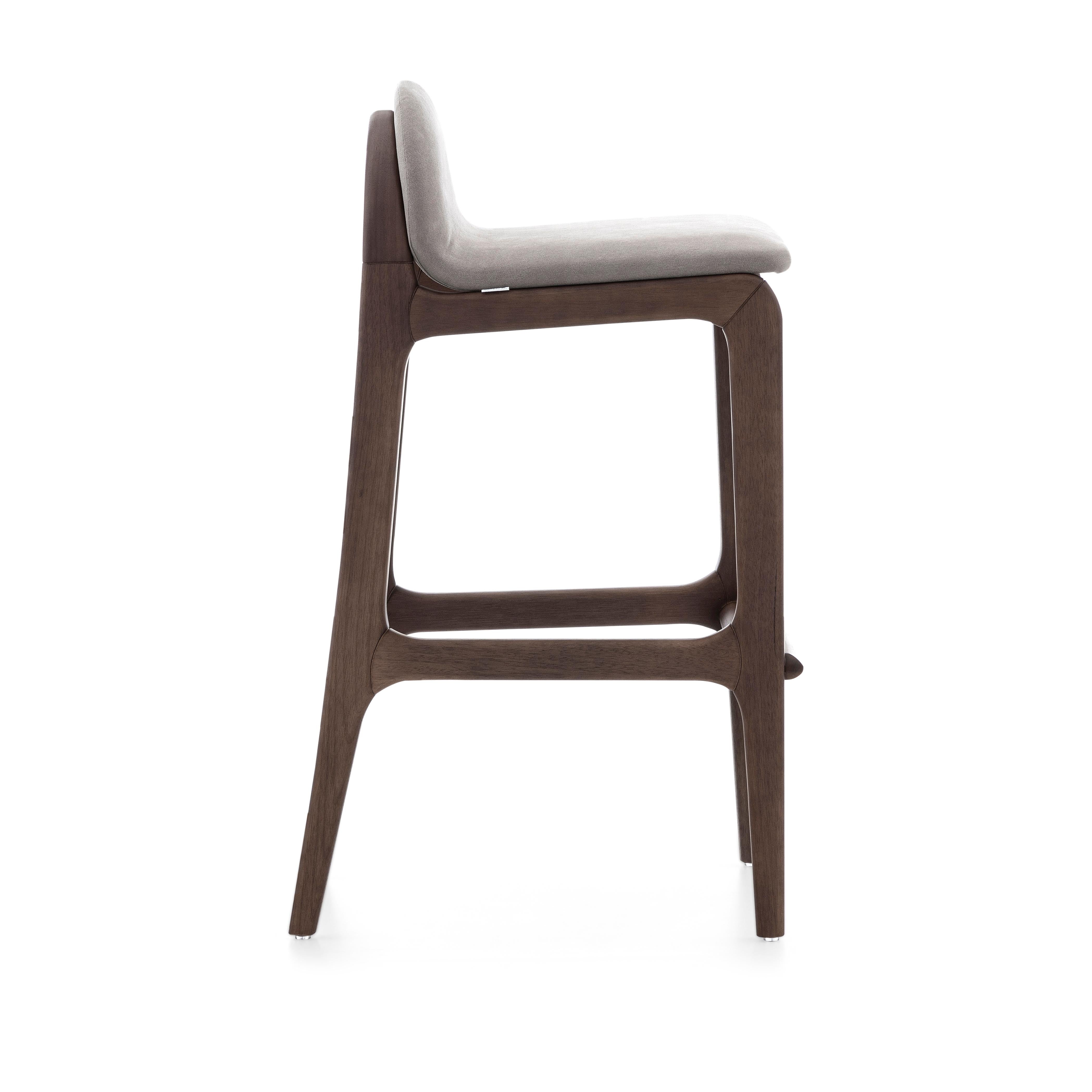 Fabriqué au Brésil par l'équipe d'Uultis Design, le tabouret de bar Ura incarne l'équilibre signature de la marque entre élégance, confort et artisanat durable. Son assise légèrement galbée, recouverte d'un doux tissu gris clair, est posée sur un