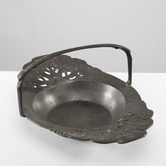 Urania. An Art Nouveau pewter fruit bowl with a loop handle floral decoration