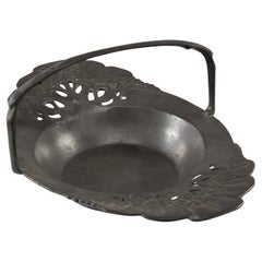 Urania. An Art Nouveau pewter fruit bowl with a loop handle floral decoration
