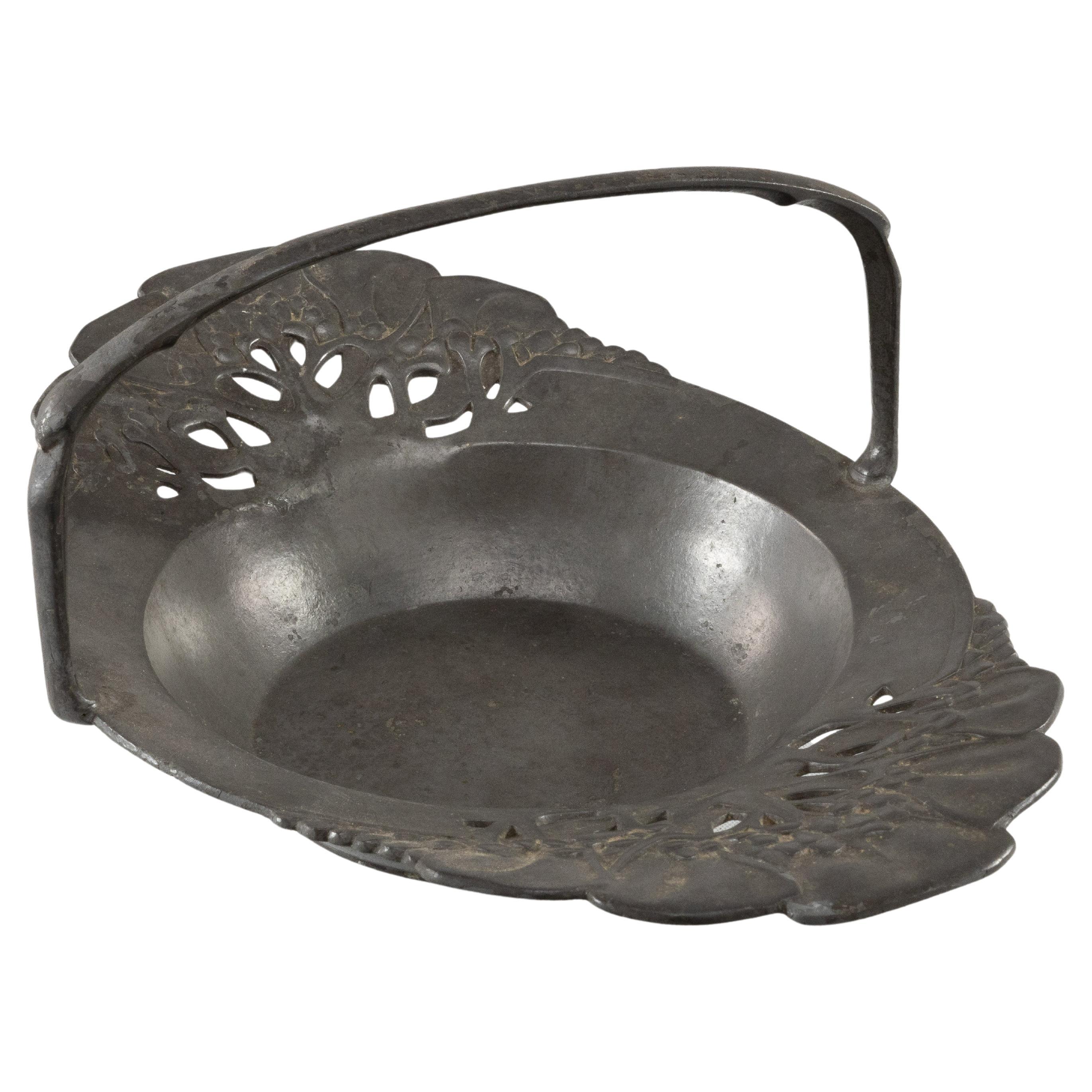 Urania. An Art Nouveau pewter fruit bowl with a loop handle floral decoration For Sale