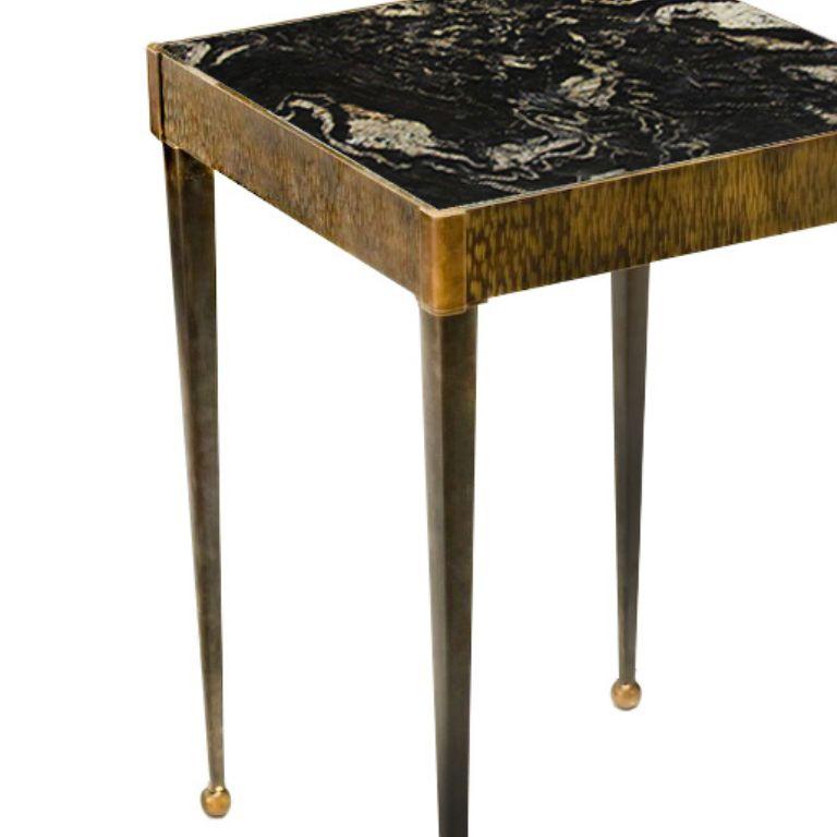 Introduce a touch of luxury to your living space with a square side table boasting a brass structure, a marble tabletop, and a finely milled band. This exquisite combination of materials creates a stunning visual appeal and a harmonious blend of