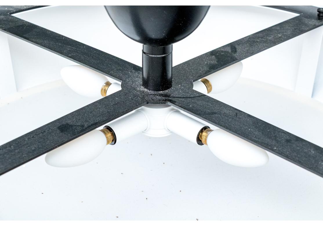 Large round semi-flush ceiling fixture by luxury and custom lighting manufacturer Urban Electric Co. with bench made fixtures from Charleston, S.C. The fixture with an X-form frame in a black powder coated finish with brass lacquered trim and