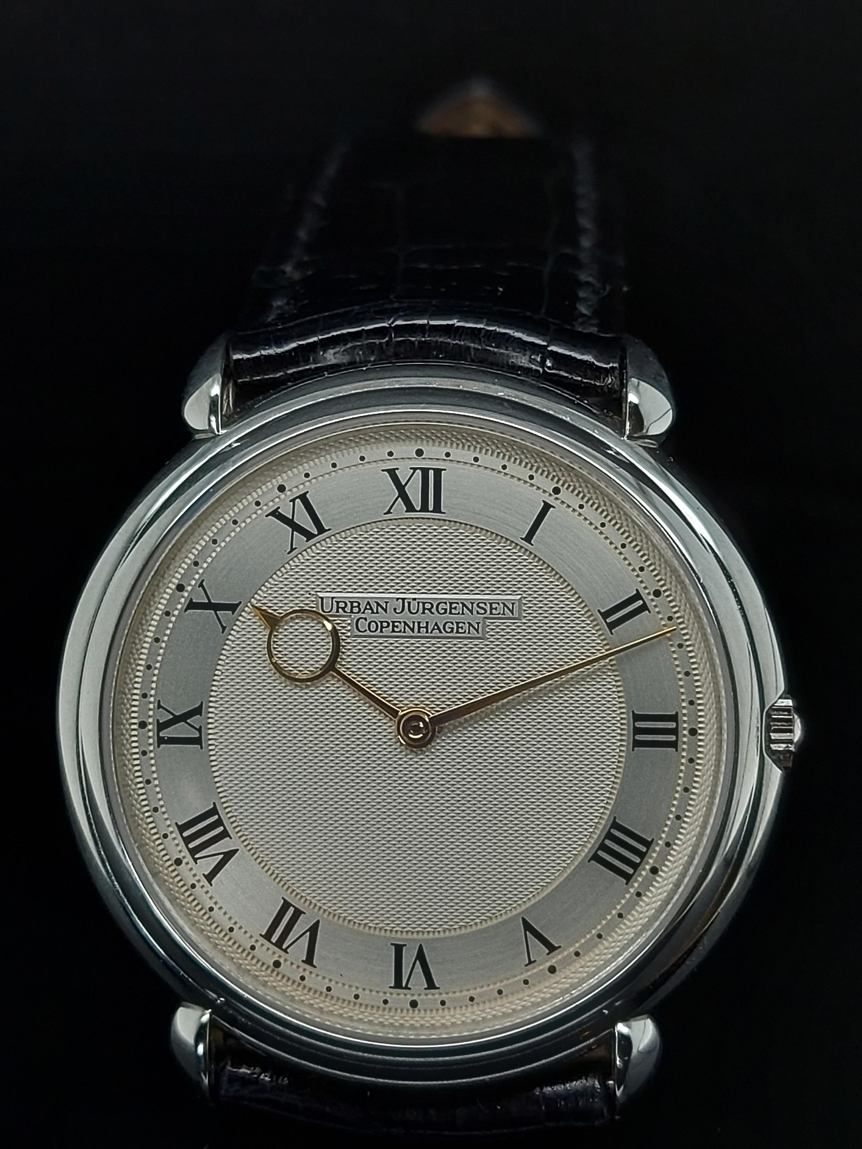 Urban Jürgensen Platinum Limited Edition Automatic Wristwatch

Reference:  ref. 5,

Movement: Automatic

Dial:   massive silver dial, Roman numerals on blank chapter ring, gold moon-style turned hands, stepped bezel,

Case: Platinum case, Diameter