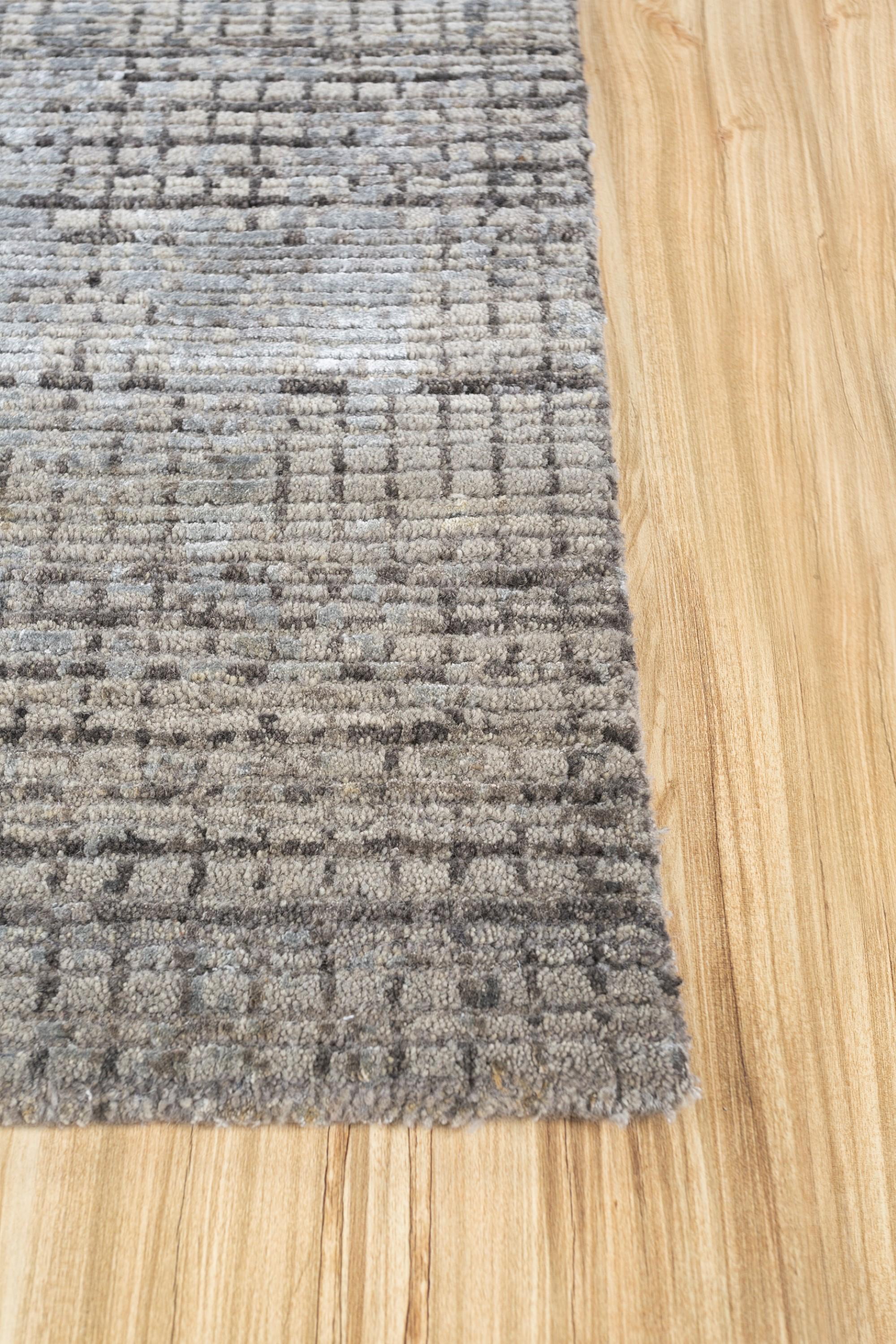 Step into the contemporary allure of 'Urban Mesh,' a hand-knotted rug . Its medium gray ground, akin to the rhythm of city life, seamlessly meets the ashwood border, creating a modern canvas. Inspired by the texture of urban landscapes, 'Urban Mesh'