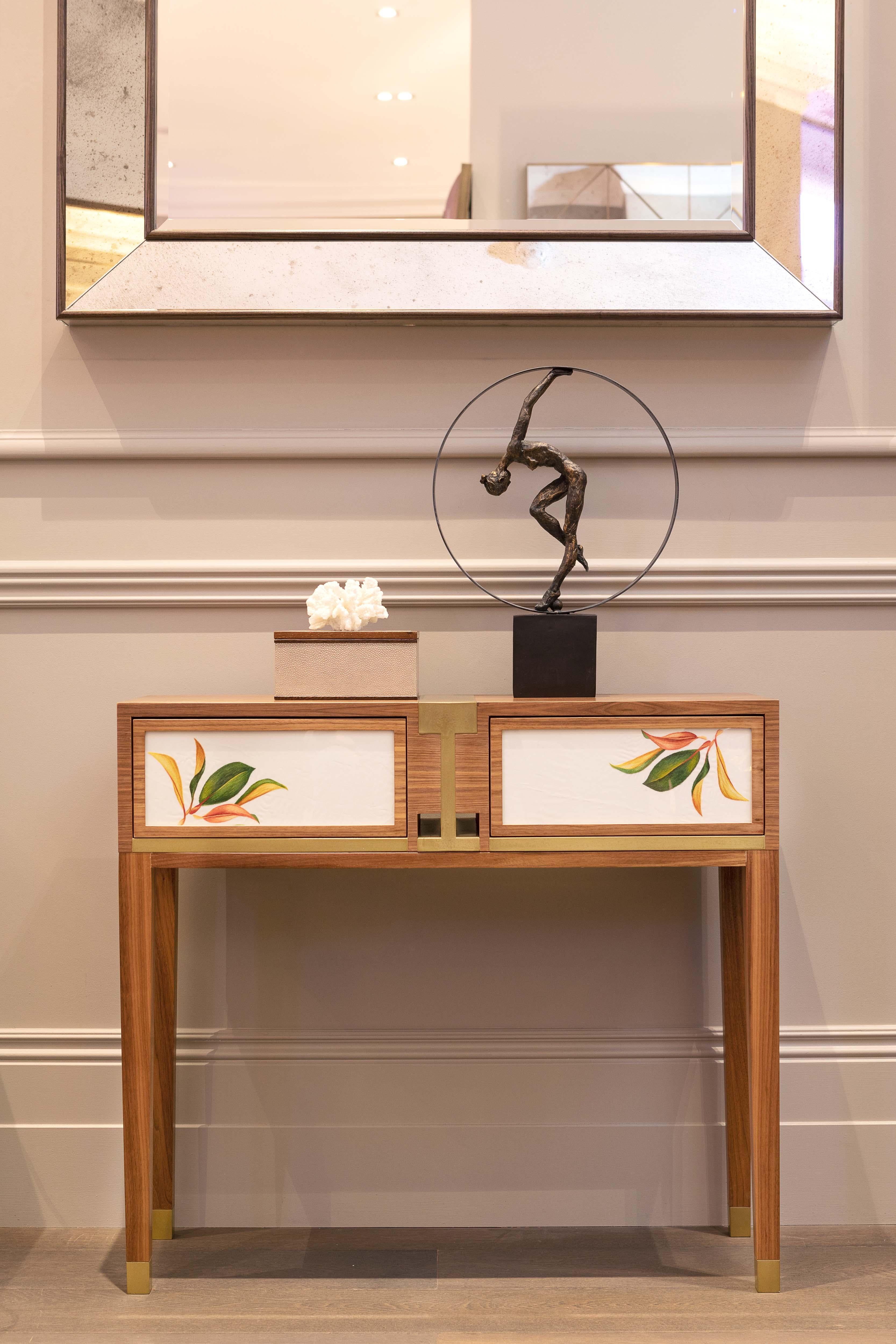 The interlocking design element is inspired by the ancient double luck character in Chinese calligraphy. The brass and veneered walnut give a prominent contrast to emphasise on the push-open panelled drawer, decorated with hand-made silk