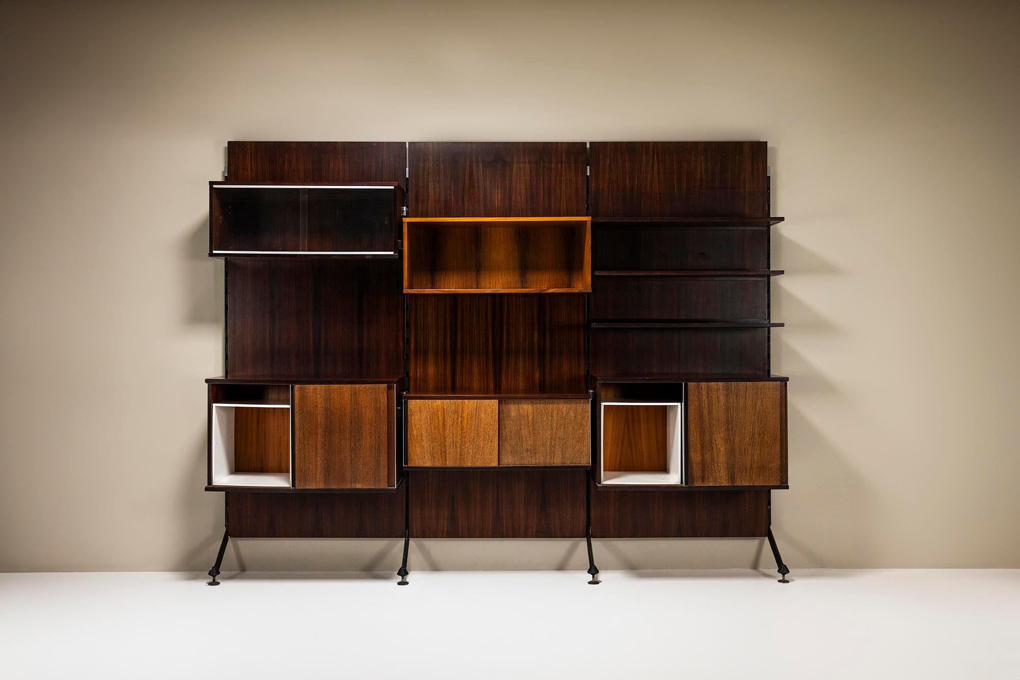 The Urio Wall System by Ico and Luisa Parisi for MIM Roma embodies the essence of Italian modernism. Crafted with exquisite rosewood panels, its sleek lines and minimalist design exude sophistication. The warm tones of the wood juxtaposed with the