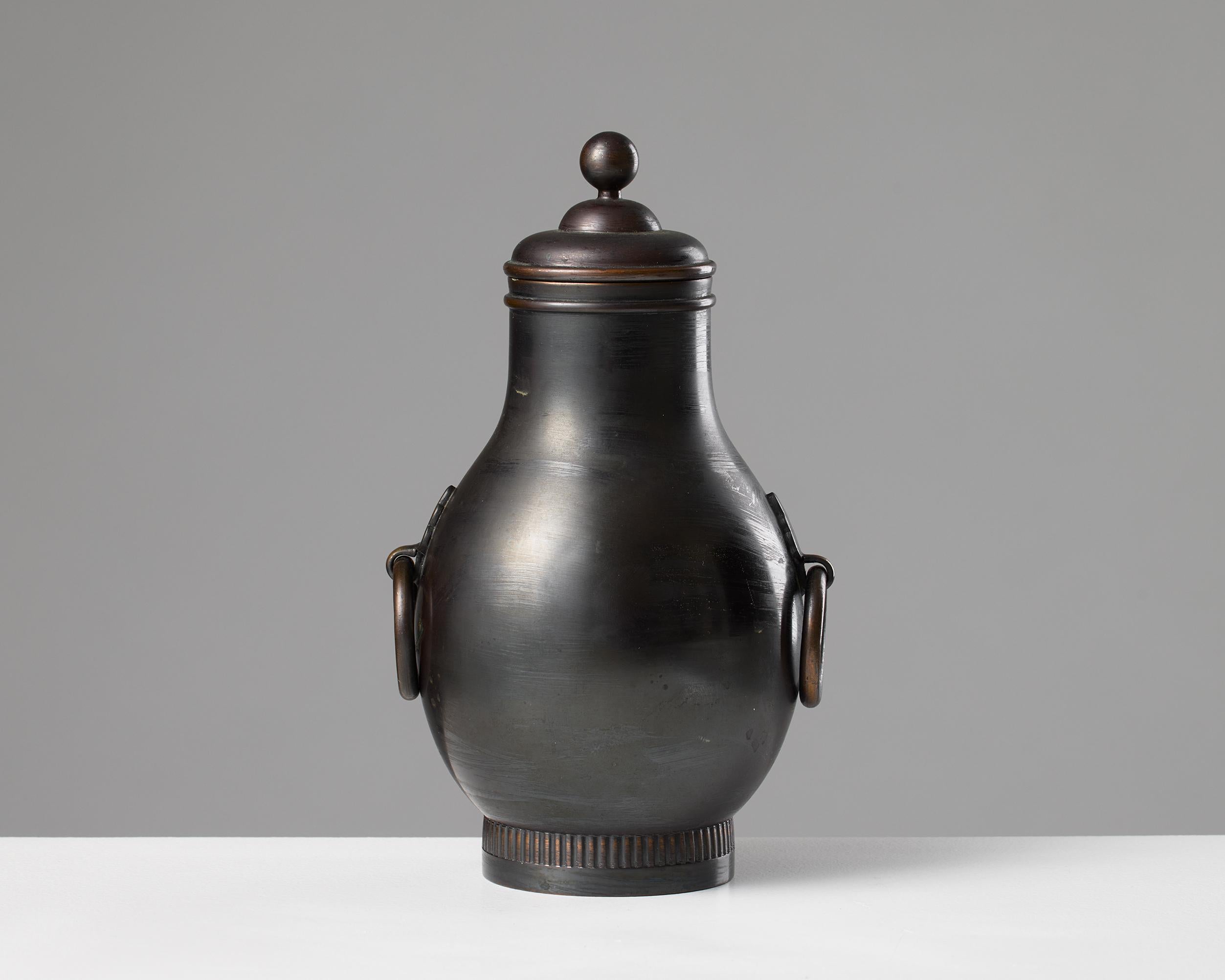 Questa elegante e rara urna in peltro, disegnata per Svenskt Tenn nel 1929, esemplifica la raffinata abilità artigianale e l'estetica senza tempo che definiscono le arti decorative svedesi dell'inizio del XX secolo. Le proporzioni equilibrate, le