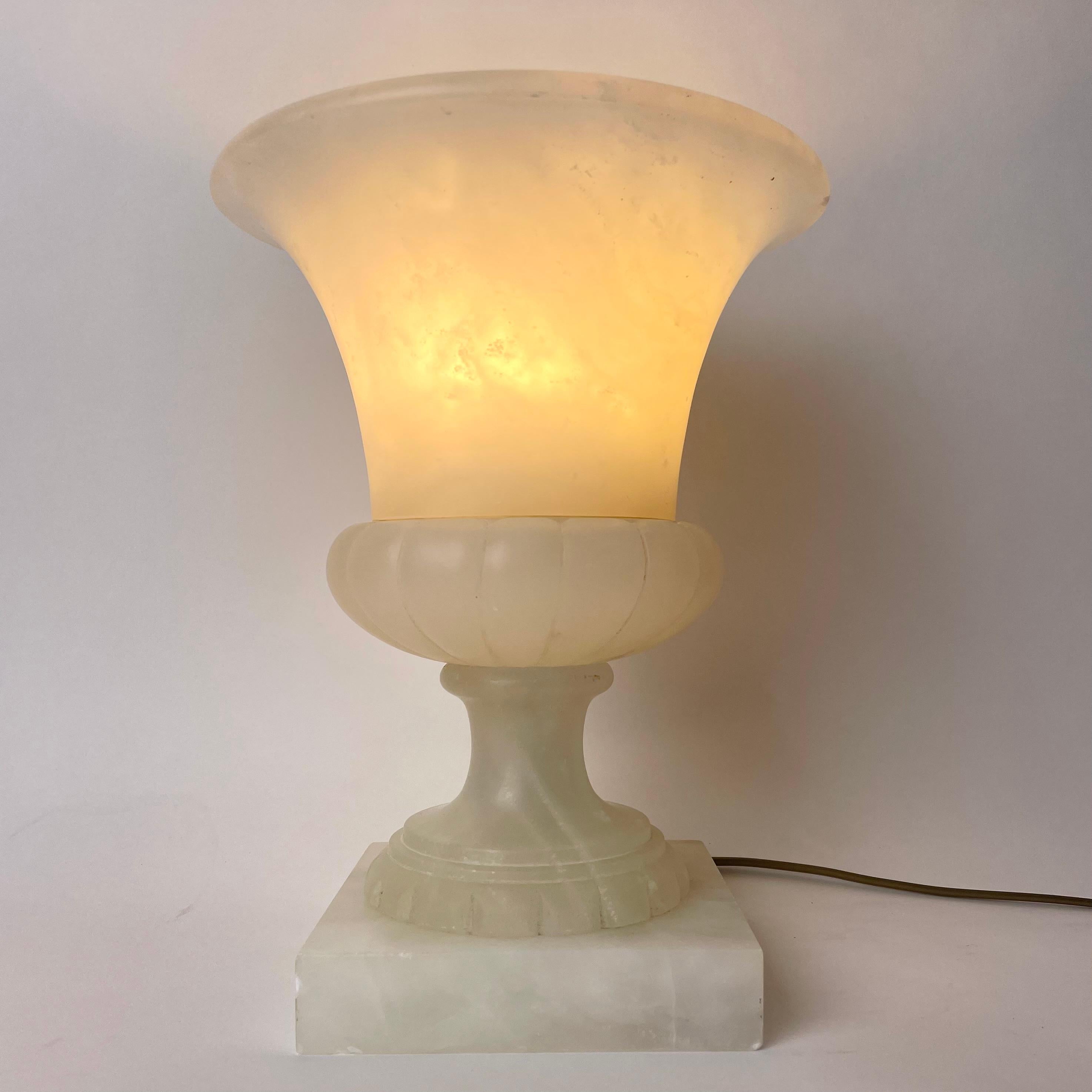 Elegante urnenförmige Tischlampe aus Alabaster, wahrscheinlich aus dem frühen 20. Jahrhundert. Sehr warmes und gemütliches Licht. 

Auf der Rückseite der Lampe befinden sich kleinere Punkte als zuvor für warme Lampen. (Siehe Bilder)

Abnutzung