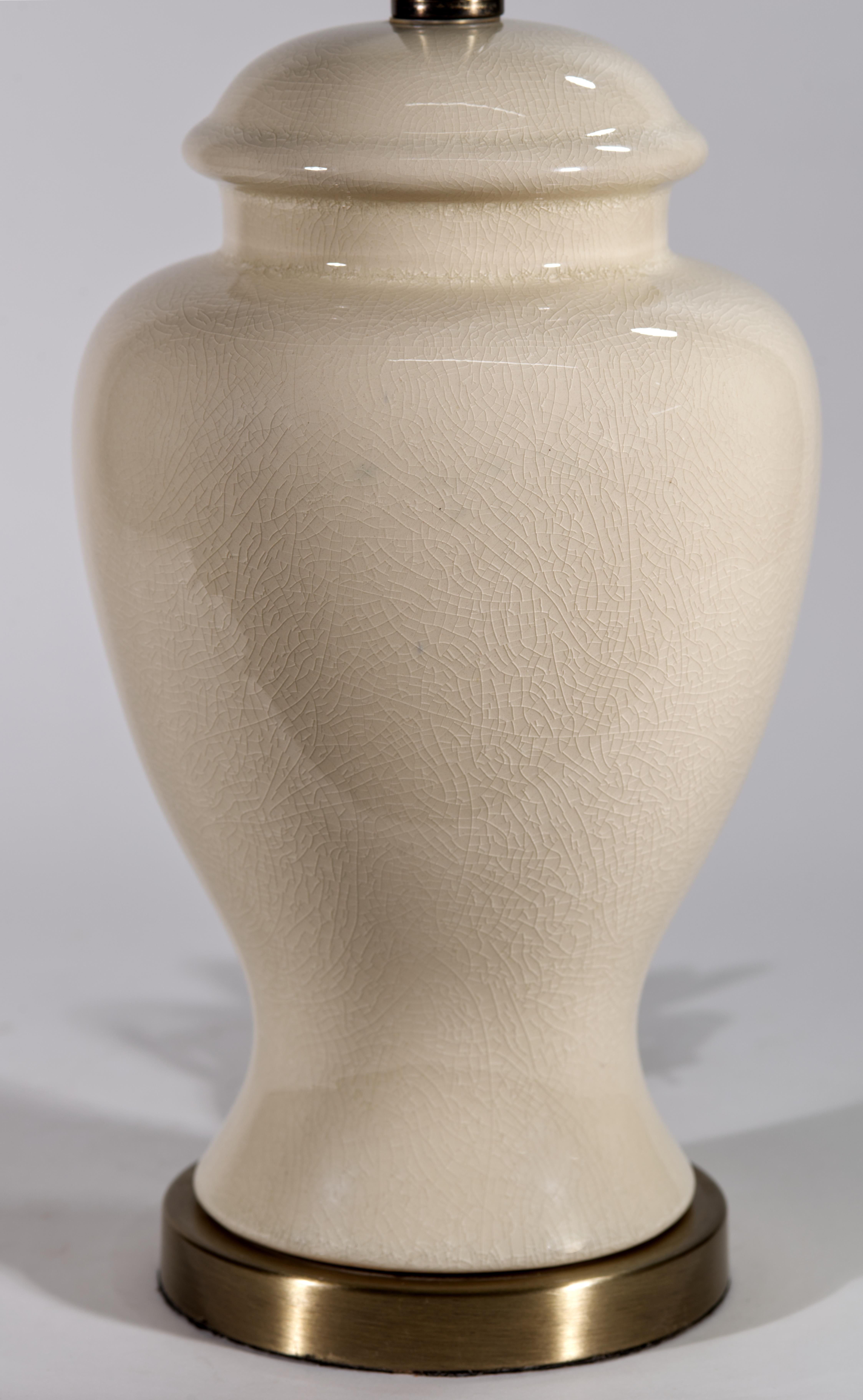 Vintage elegant table lamp features sculptural urn-shaped ceramic or porcelain body with eggshell off-white glaze. Highly detailed, fine craquelure glaze texture is emphasized by the glossy clear top glaze that adds depth and visual interest to