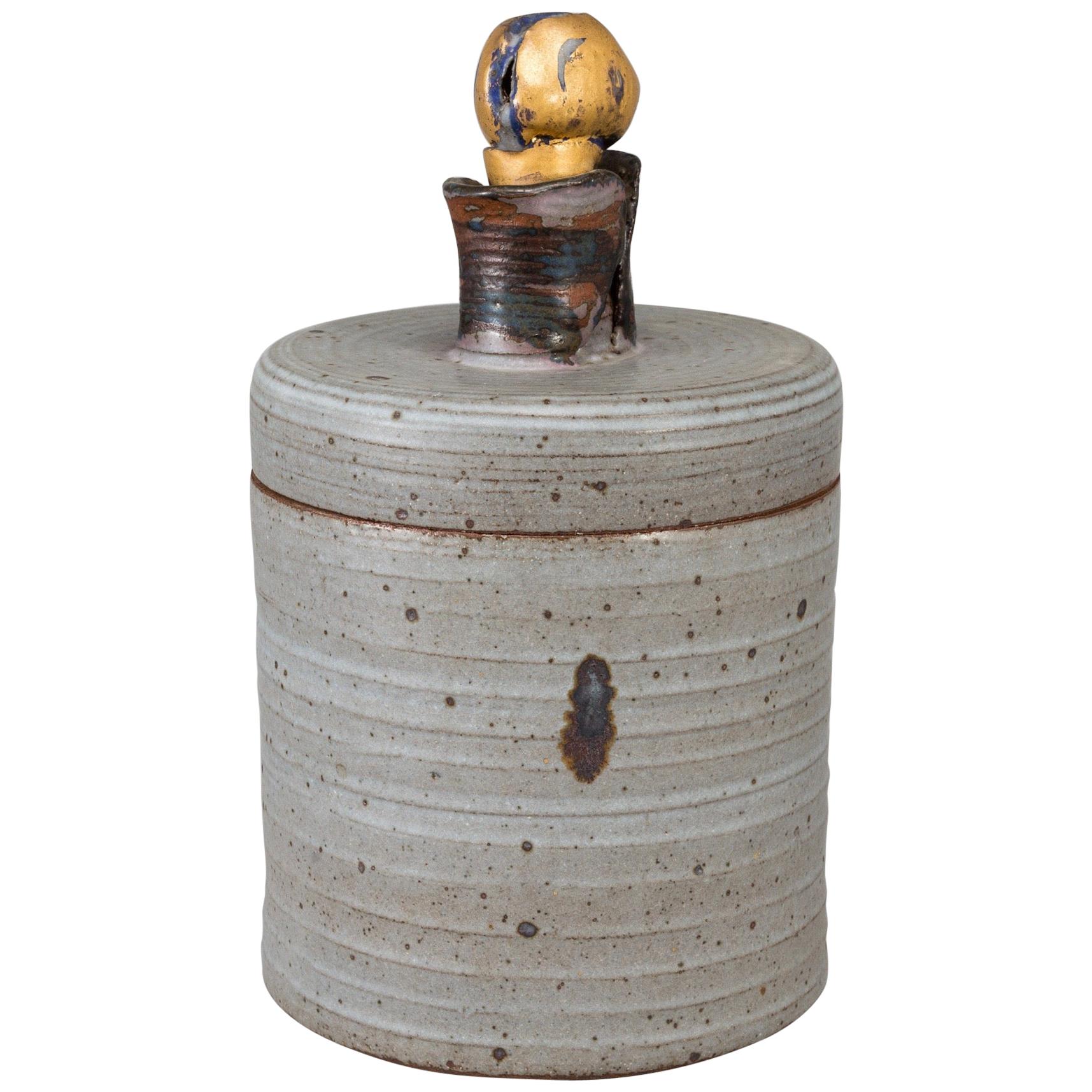 Grand urne en céramique par Lisa Larson Gustavsberg Studio, Suède, 1980, gris dans l'ensemble avec un couvercle et une poignée de forme organique avec différentes couleurs ; le bouton supérieur est bleu et se chevauche en or ; Suède 1980 ; excellent