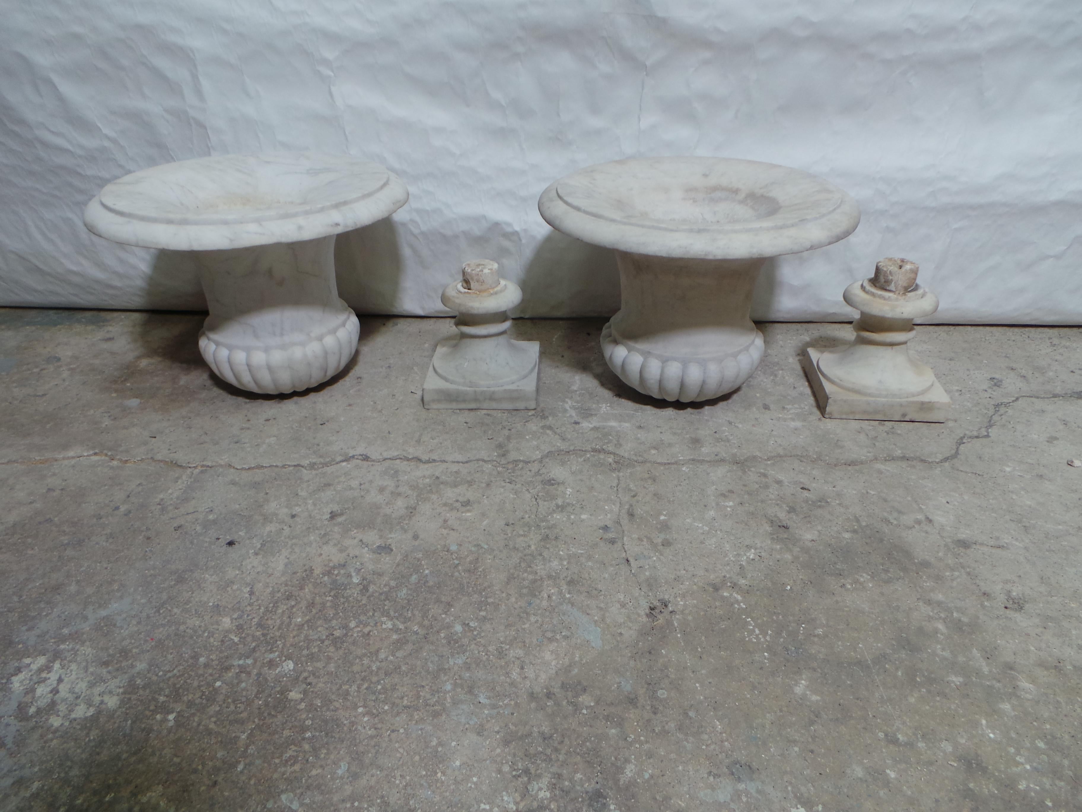 Il s'agit d'un ensemble unique d'urnes en marbre blanc. Elles sont uniques car elles sont composées de deux pièces et reposent sur une base.