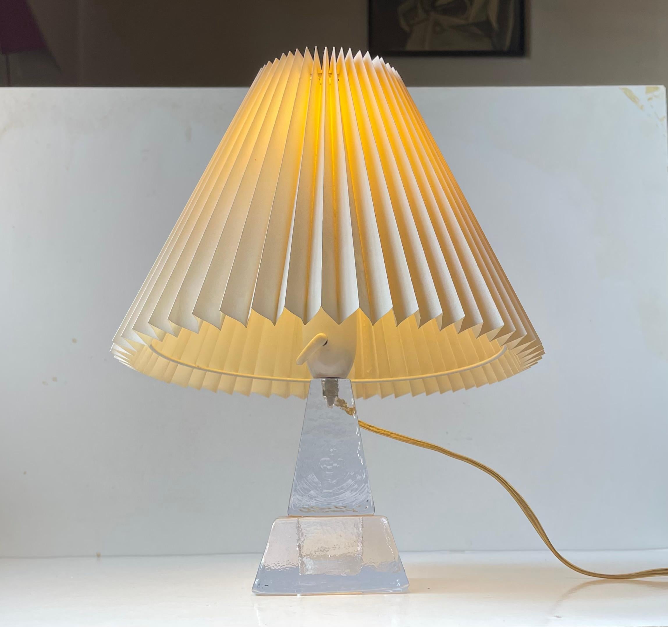 A stylish architecturally perceived small table light from Ursula Glasbruk in Sweden, circa 1960s. Its base is fashioned from textured thick ice glass. It features its. original white bakelite socket with practical on/off switch. It comes with a