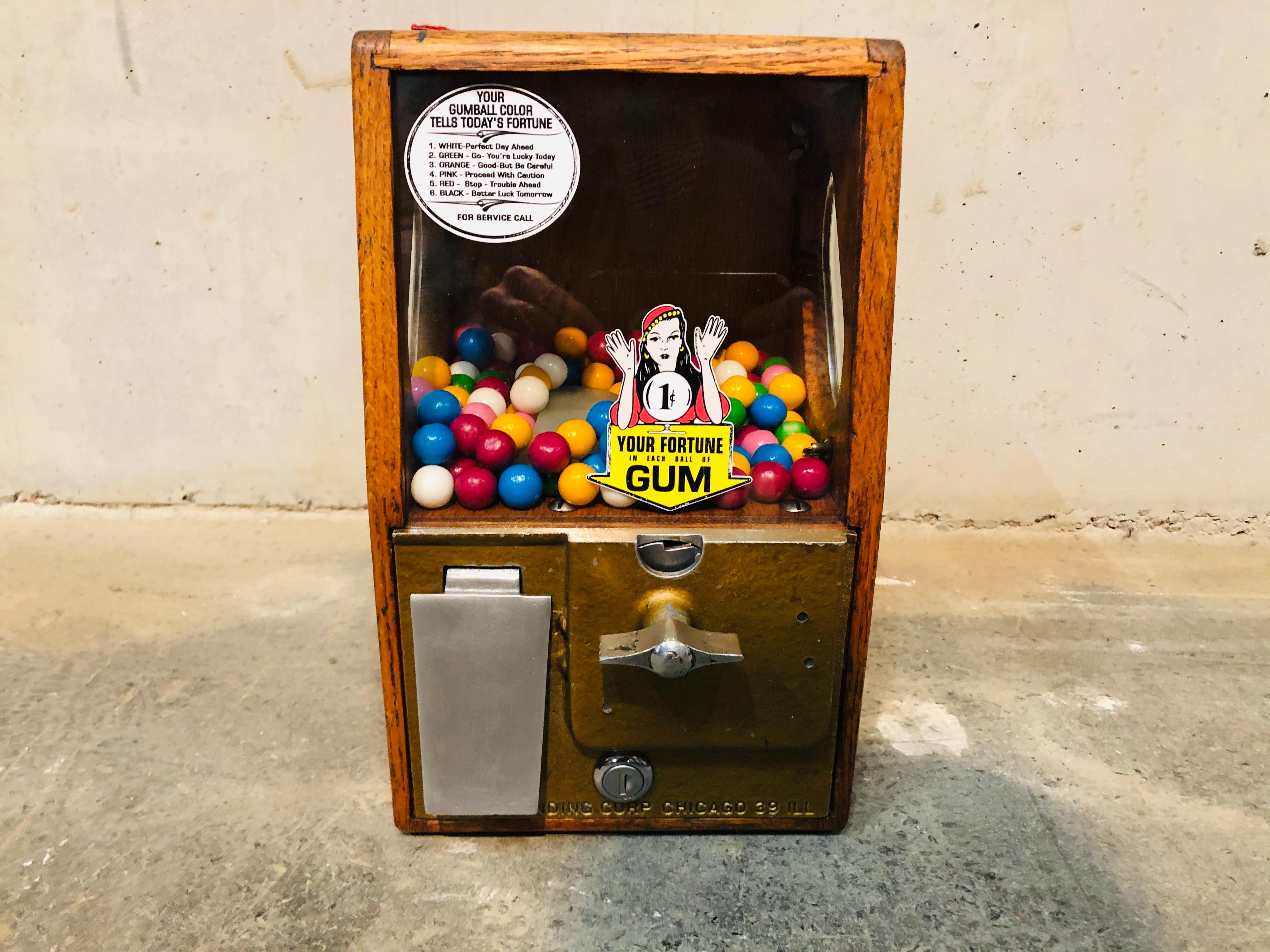 This little beautiful vending machine is from the 1950s, originally from the USA.
Crafted out of wood and metal pieces it is still functioning. Its colorful bubble gums are new and you can also use 10 Cents (€) instead of $ to get a bubblegum from