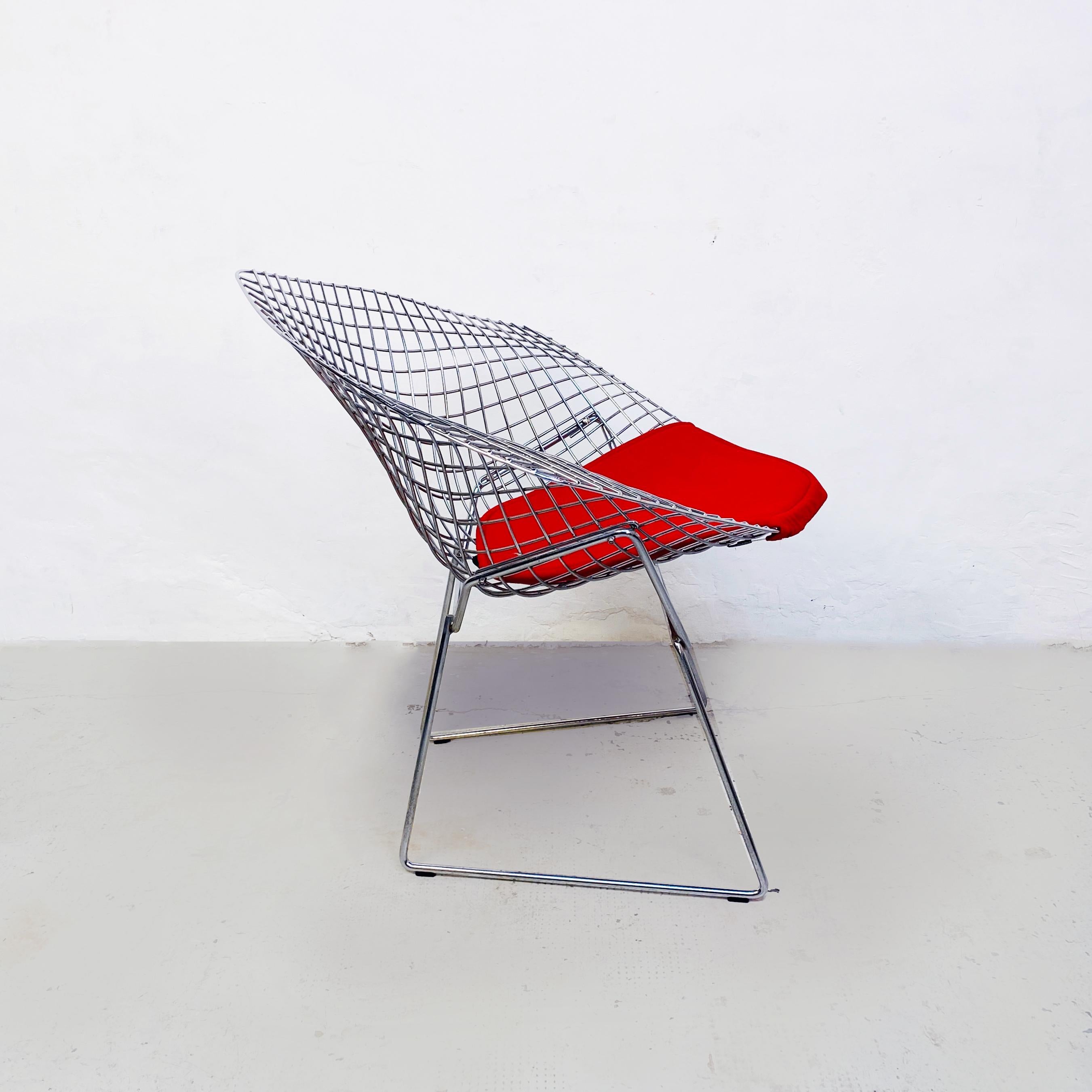 USA mid-century Red cushion and steel Diamond armchair by Bertoia for Knoll, 1970s.
Diamond armchair with structure in welded steel rods with polished chrome plating. The red cushion attaches directly to the frame with hidden monofilament and metal