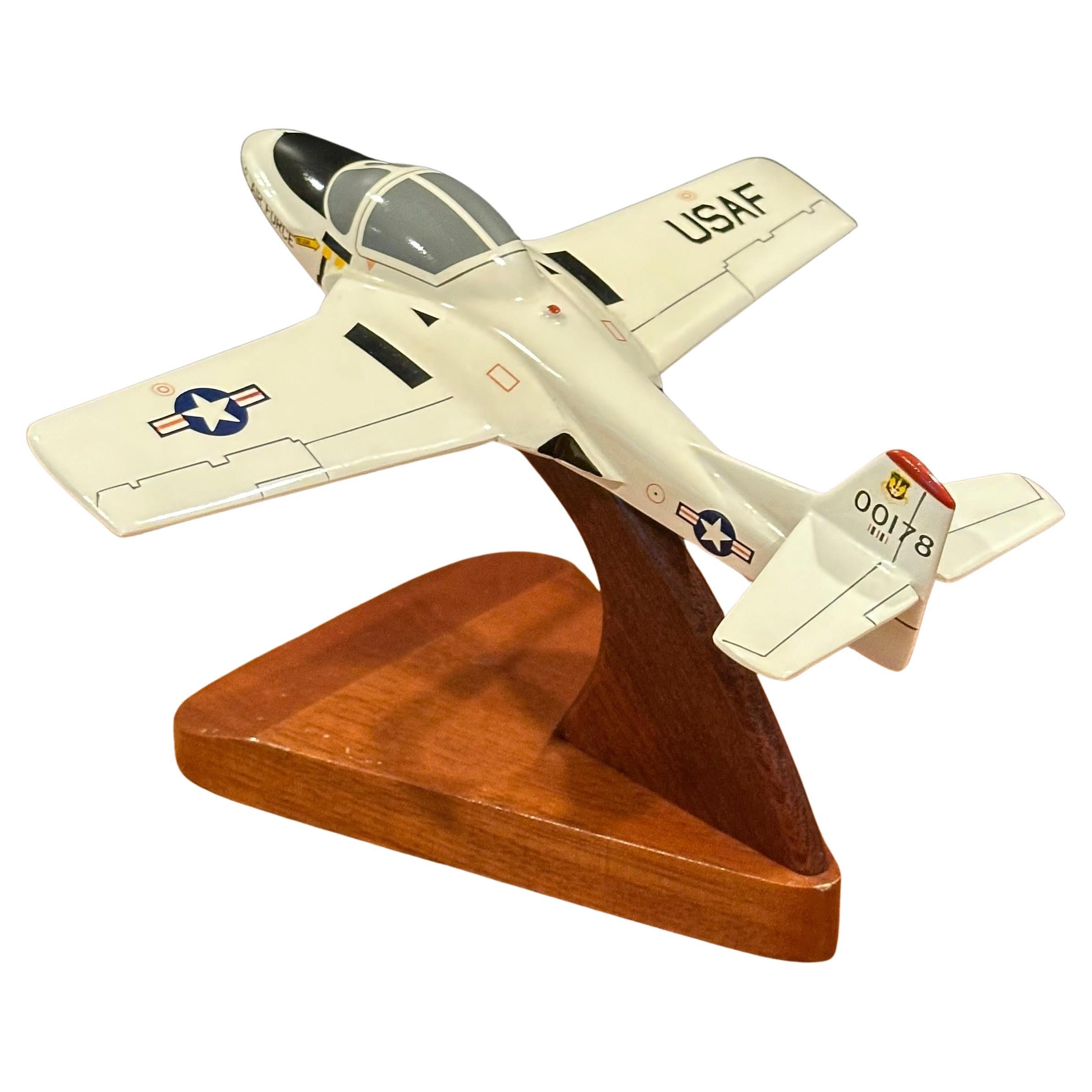 A very cool U.S.A.F. North American Aviation Cessna T-37 Tweet airplane solid wood contractor desk model by Toys and Models Corporation, circa 1980s. The plane is in very good condition and is constructed of solid wood with a lacquer paint finish