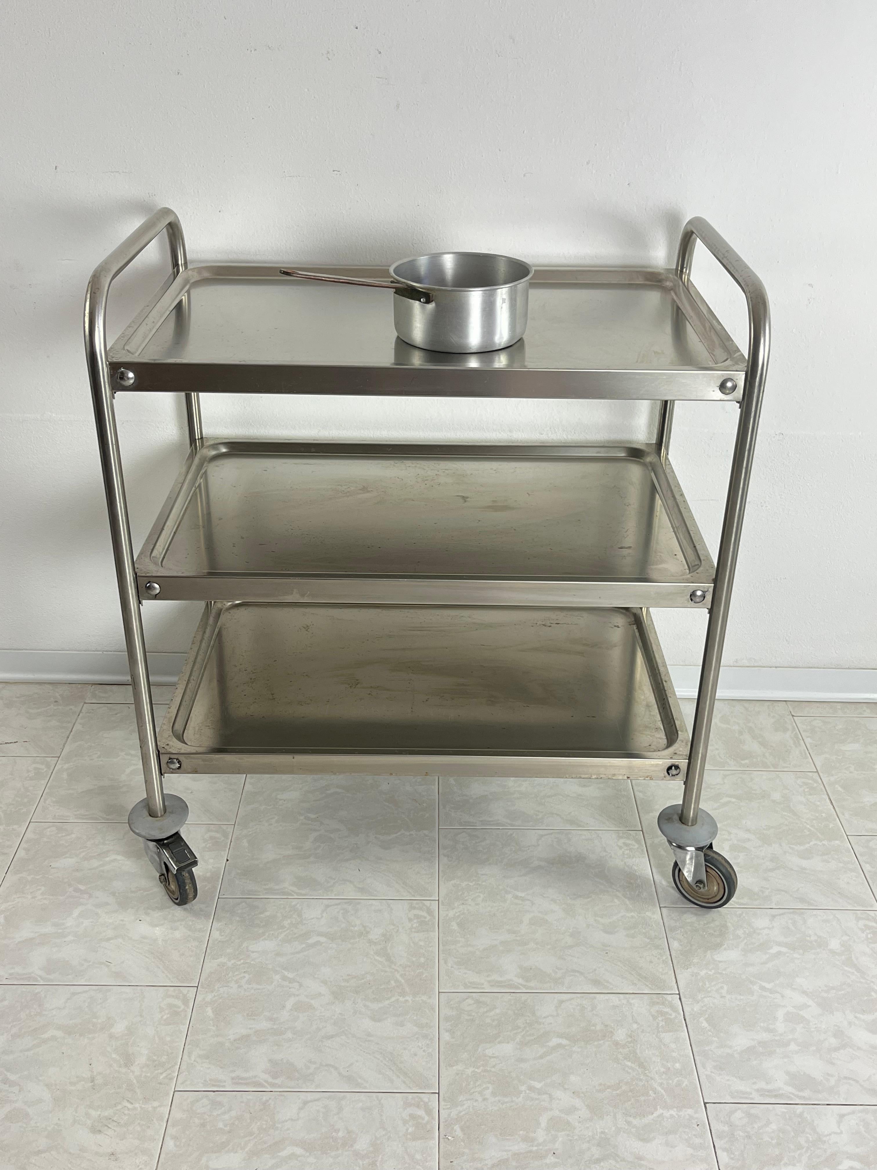 Useful steel serving trolley with swivel wheels, Italian design 1980s
Found in a university canteen. 
Good condition.
It will be shipped disassembled.