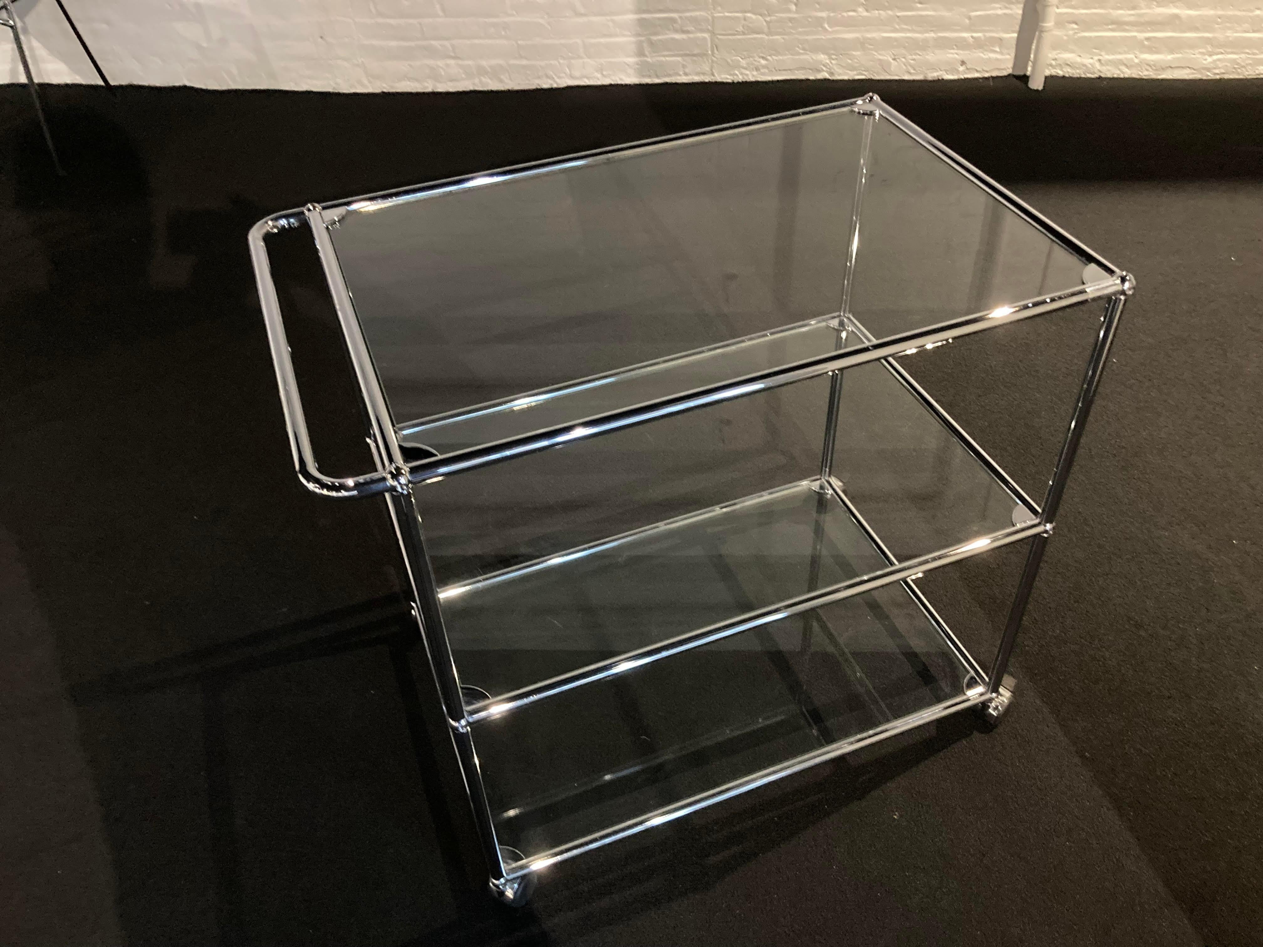 This modern bar cart offers plenty of space for all your entertaining and storage needs. . Designed by Swiss architect Fritz Haller and Paul Schaerer in 1963. Made from chrome plated steel tubes, the USM Haller system is built to last for
