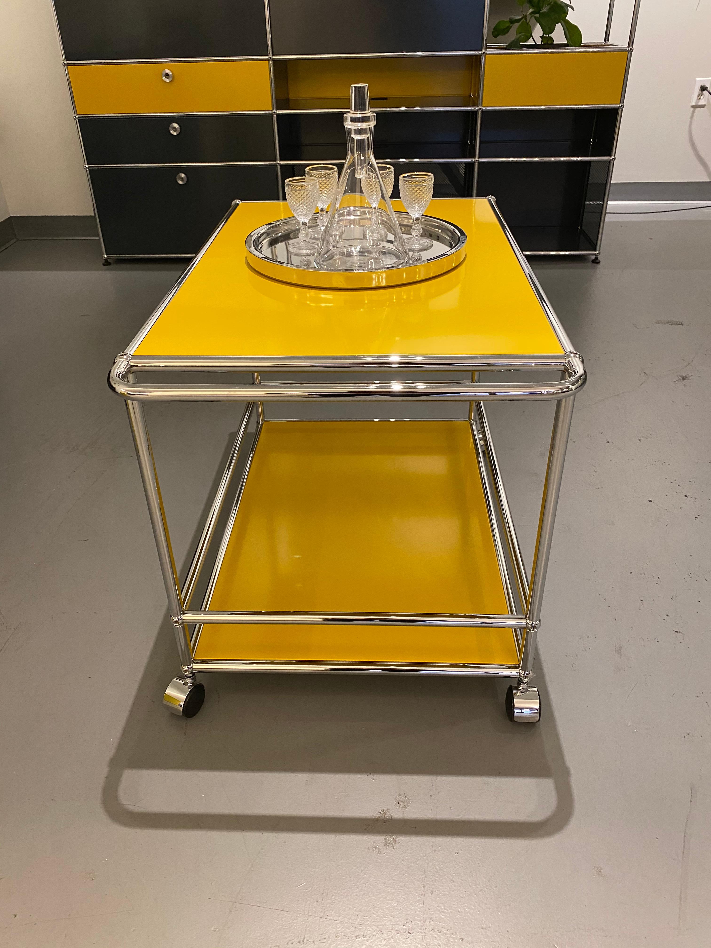 This modern bar cart offers plenty of space for all your entertaining and storage needs. . Designed by Swiss architect Fritz Haller and Paul Schaerer in 1963. Made from powder coated steel and chrome plated steel tubes, the USM Haller system is