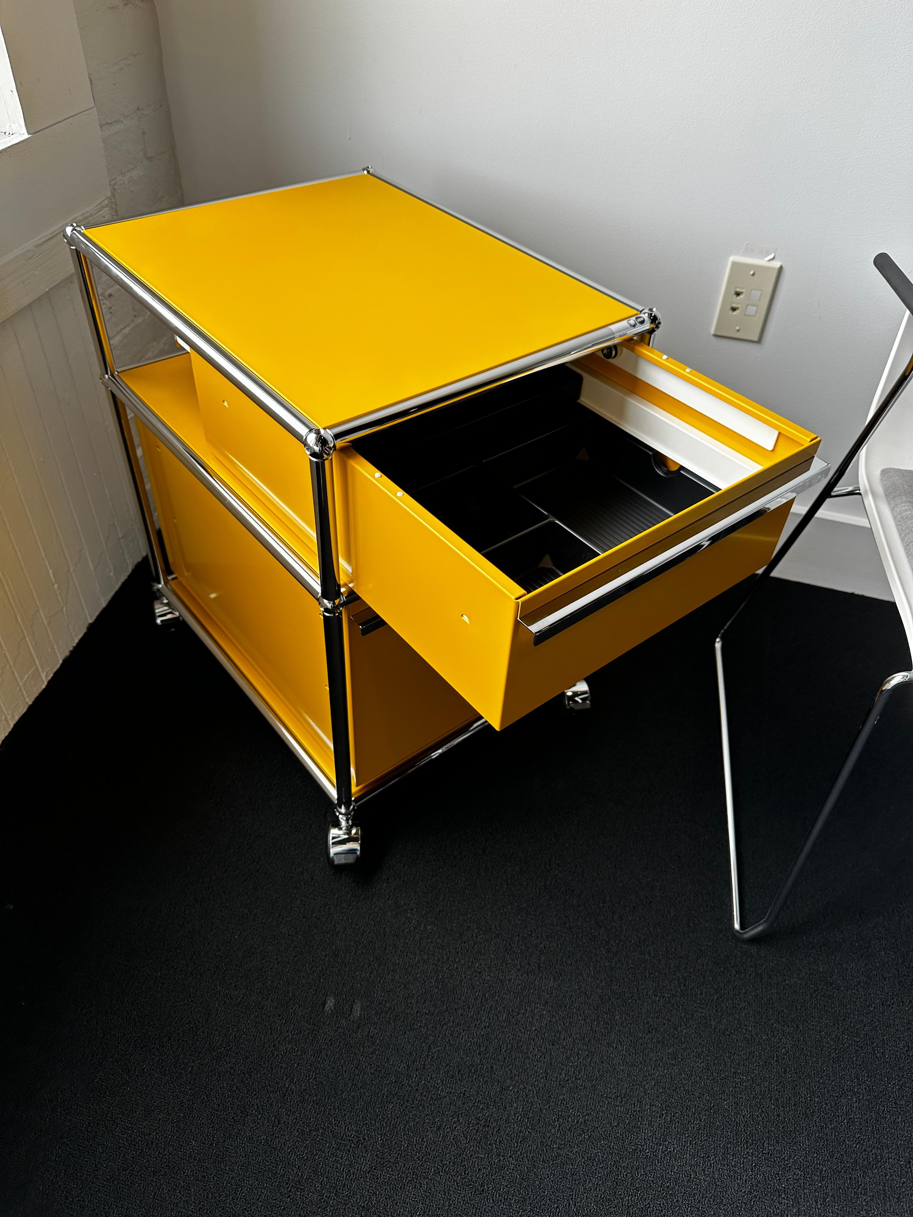 Offered by M2L.
It has top drawer inserts
LxDxH: 523x418x605 mm
Material: metal
Colour: golden yellow
2x open compartment
2x compartment incl. drawer with handle (without lock)
incl. castor, soft
With one drop down door. Designed by Swiss architect