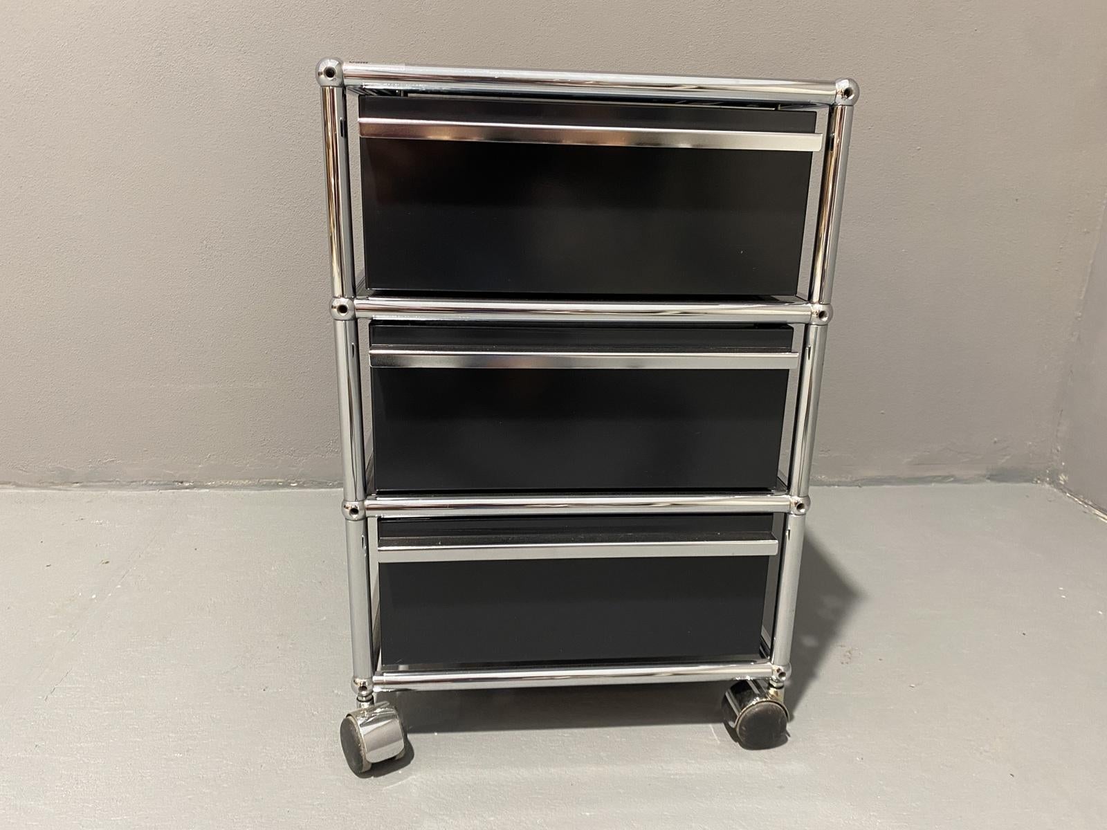 It was made in the 1970s in Switzerland and has three pull-out drawers, making it a versatile addition to any room. The black panel adds a touch of elegance to any space and is perfect for those who want a sleek and sophisticated look. It has a