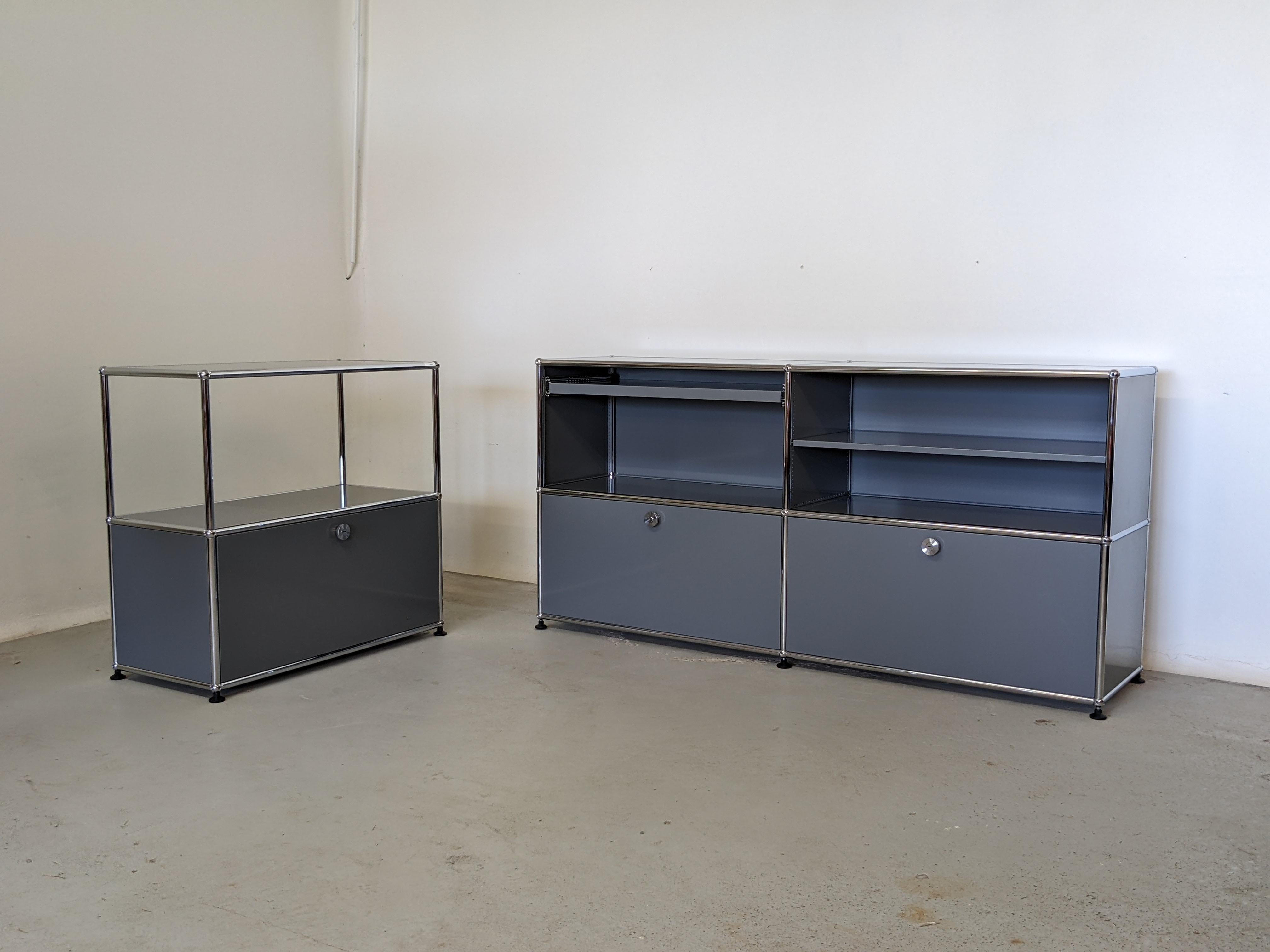 Set of 2 storage systems by USM Haller.
1 credenza C2 and 1 strage system C1.
Made of anthracite grey powder coated metal and chrome metal.

The credenza features 2 pull out drawers on the bottom, a pull-out shelf and a regular shelf on the top.