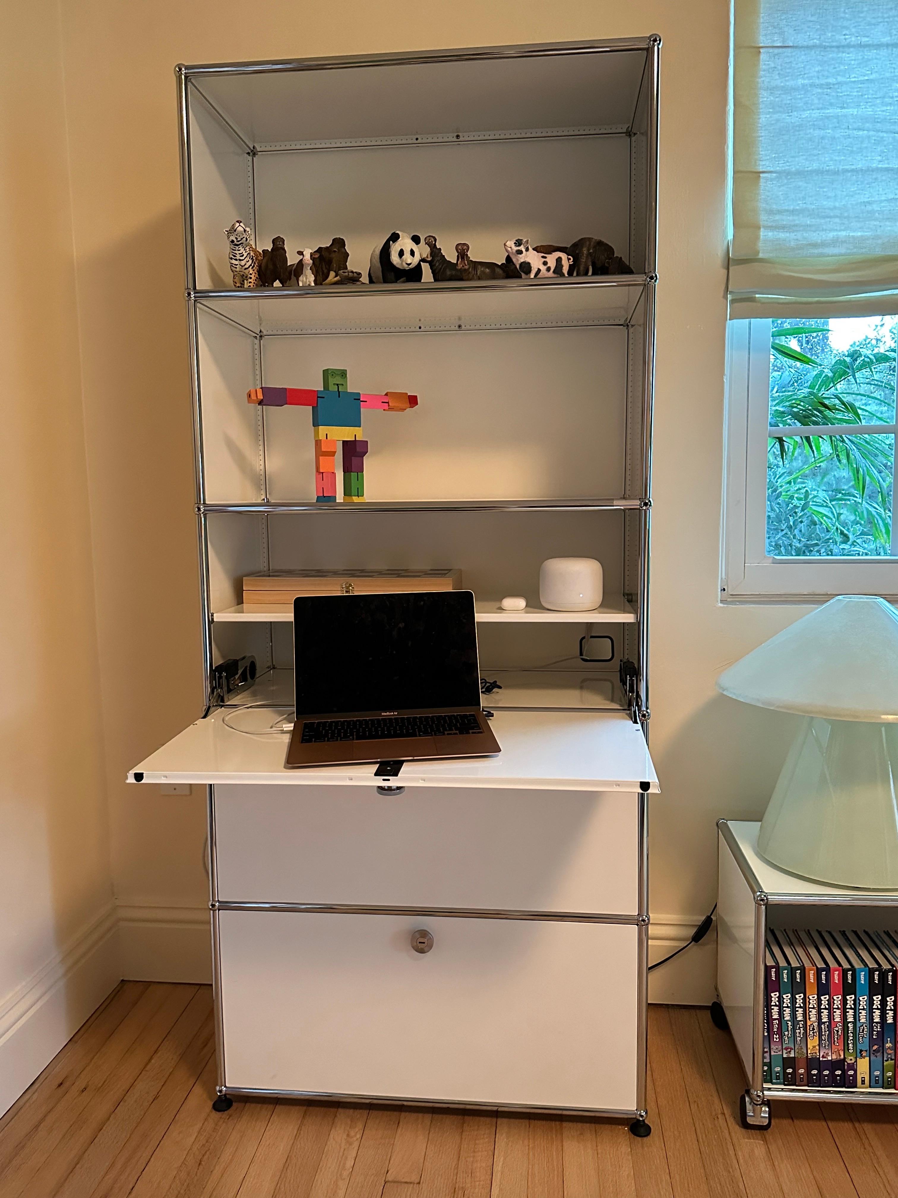 The multi-purpose storage unit with drop down doors and one bottom drawer that locks with the twist of a coin. There is a cable cut out in the top compartment to set up a work space.