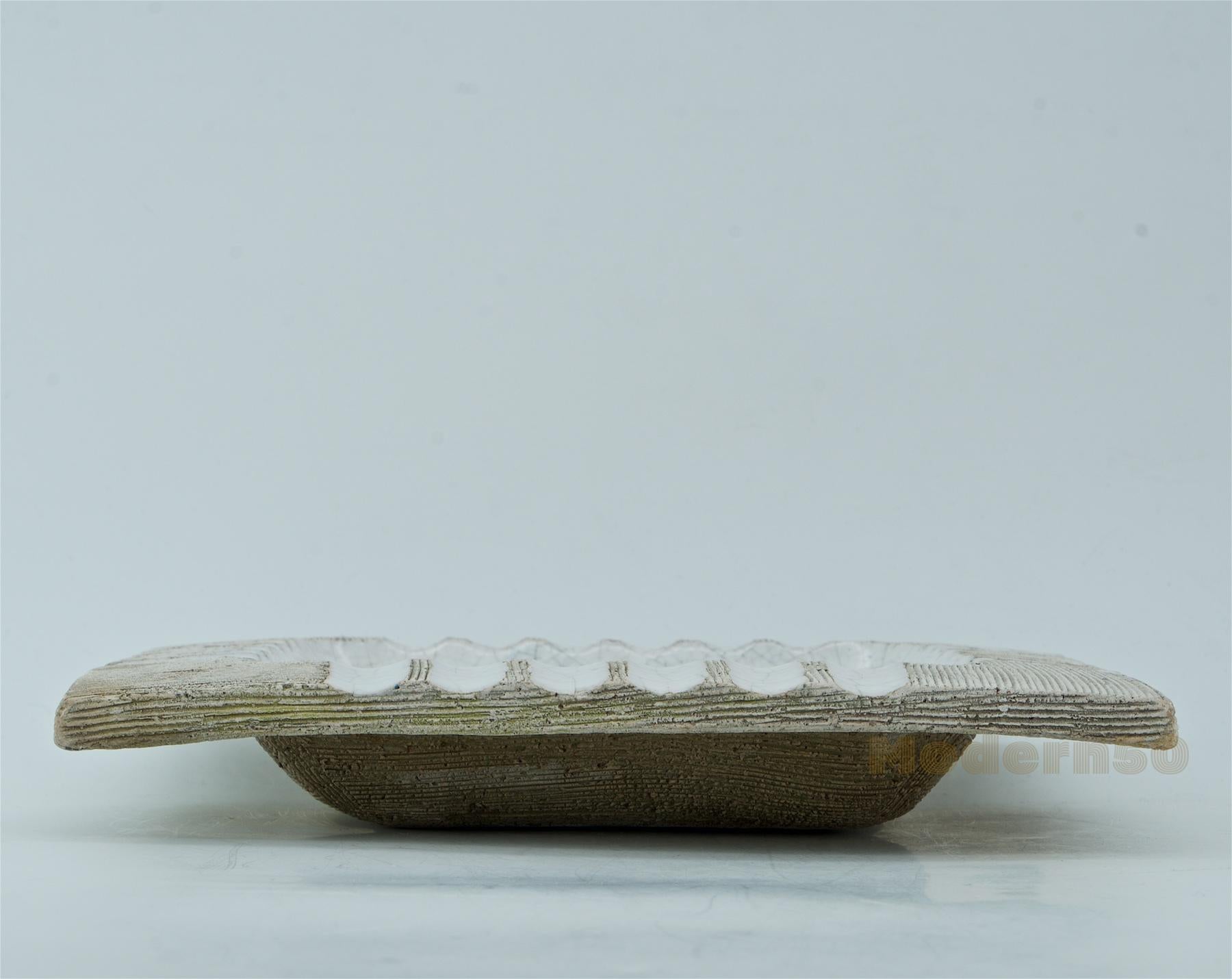 Crackle white glaze on incised unglazed ashtray dish.