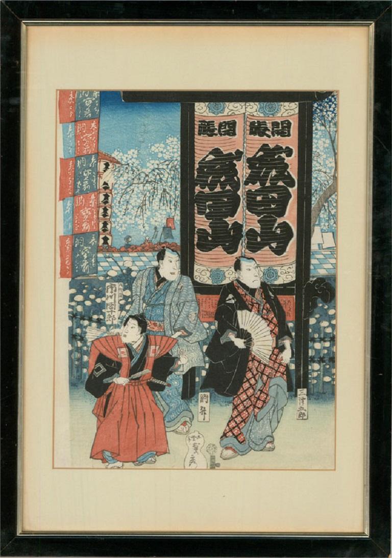 A vibrant and bold ukiyo-e woodblock showing three kabuki actors in traditional attire surrounded by banners. Cartouches with kanji narrate the story around them. The artist's signature can be seen in a gourd cartouche a the lower edge with the
