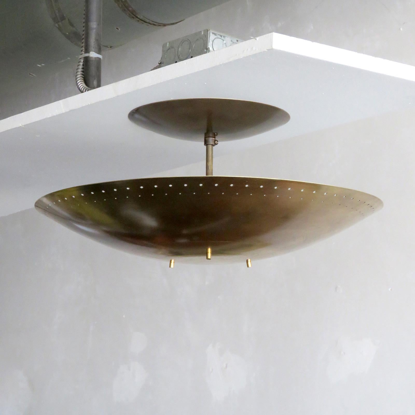 Elegant ceiling flush mount light Utah-18™, designed by Gallery L7, handcrafted and finished in Los Angeles from American brass, suspended perforated raw, aged brass disc (18inch diameter). Six E12 sockets per fixture, max. wattage 60w each, wired