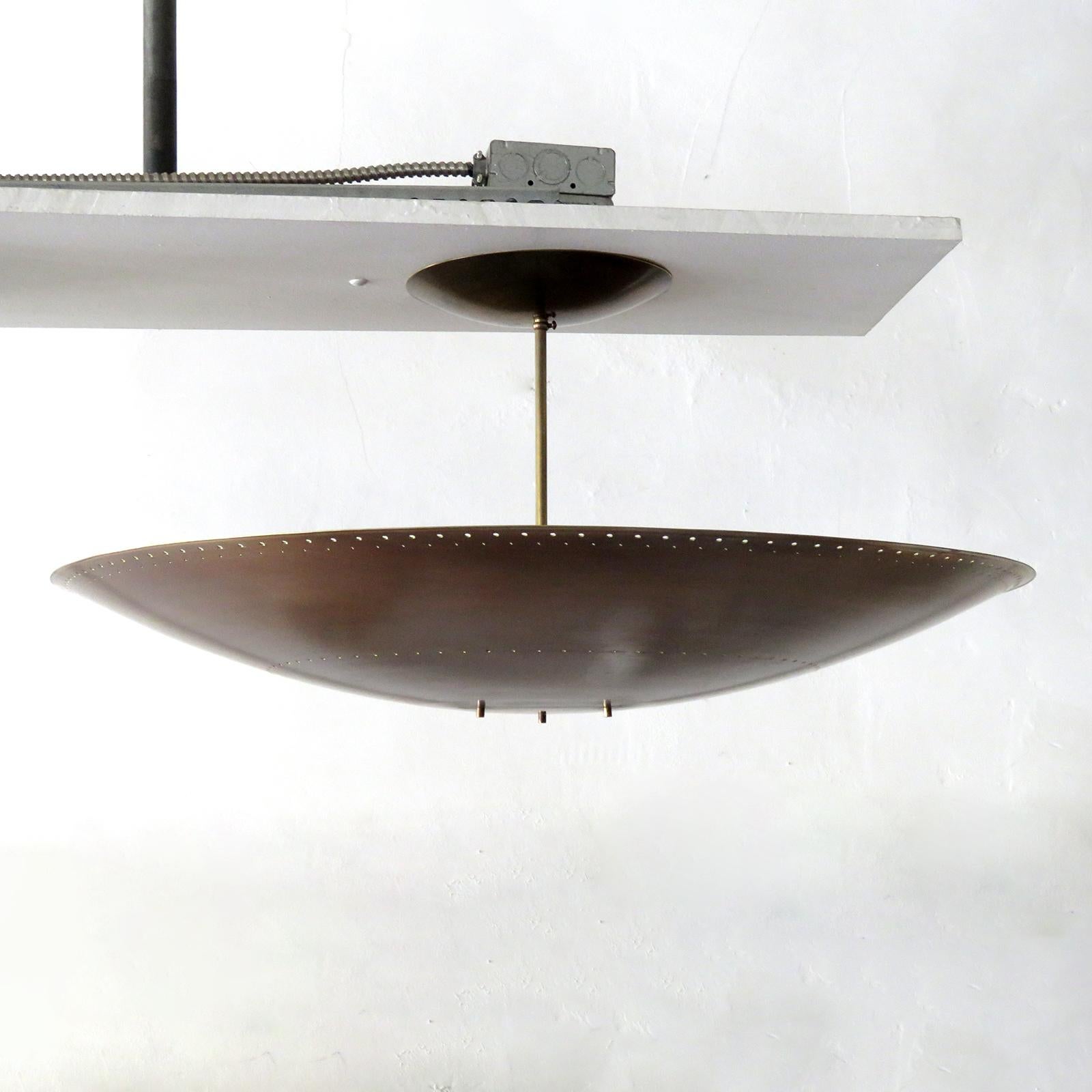 Large-scale ceiling flushmount light Utah-30 by Gallery L7, handcrafted and finished in Los Angeles from American brass, suspended perforated aged, raw brass disc (30inch diameter). Six E12 sockets per fixture, max. wattage 40w each, wired for US