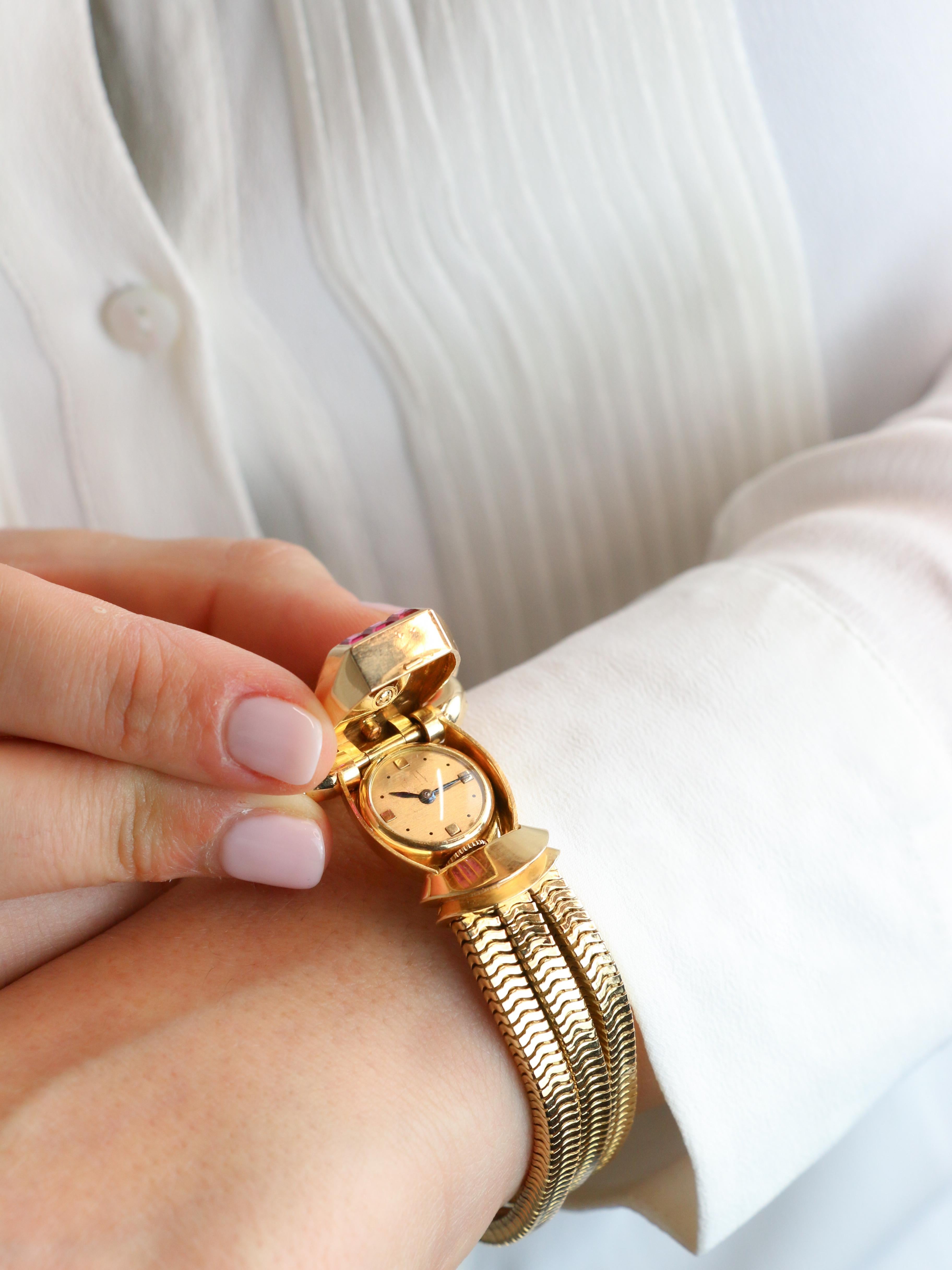UTI - Geheime Uhr aus Gold, Diamanten und Rubinen

Uti - Geheime Uhr aus 18k Gold (750°/°°), Platin, Diamanten und Rubinen. Der Hauptteil, der an die typischen Panzermotive der 1940er Jahre erinnert, ist mit zwei Reihen von sieben Diamanten