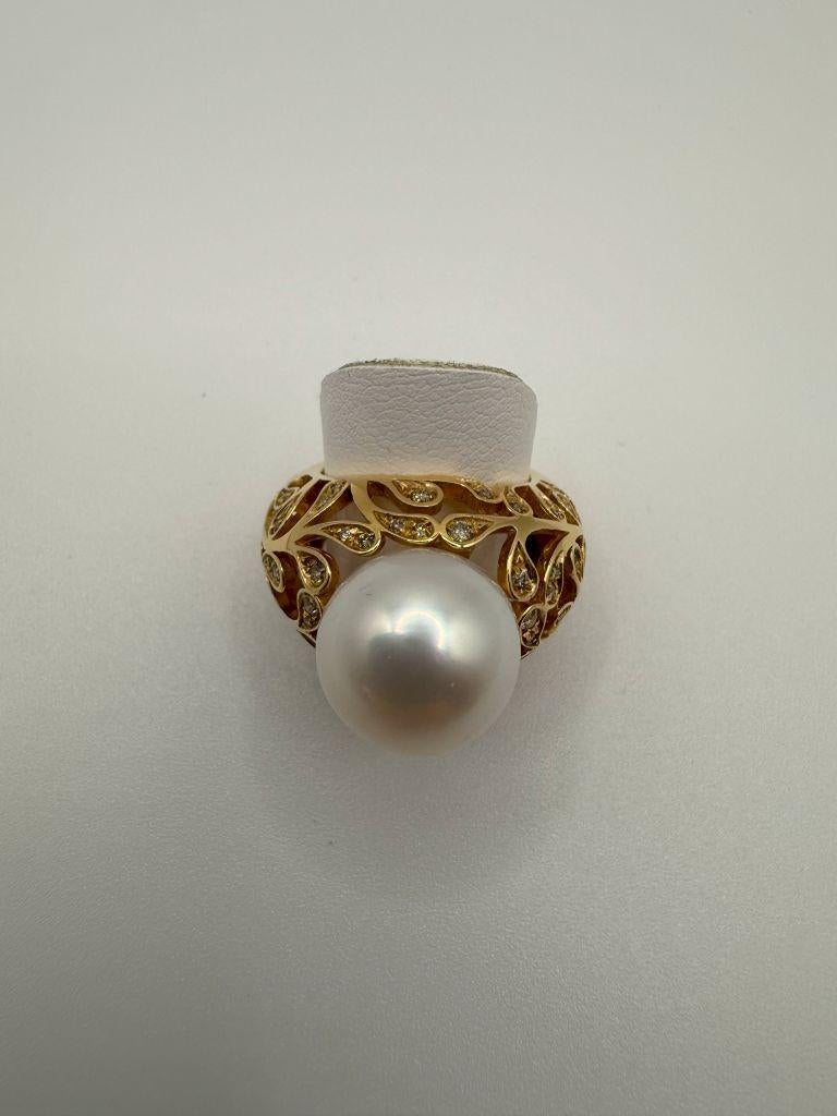 The Utopia Bolero 18K Yellow Gold Ring is a breathtaking fusion of luxury, artistry, and timeless elegance. At its heart sits a magnificent 13mm South Sea Pearl, renowned for its silky, luminous surface that shifts between shades of ivory and cream,