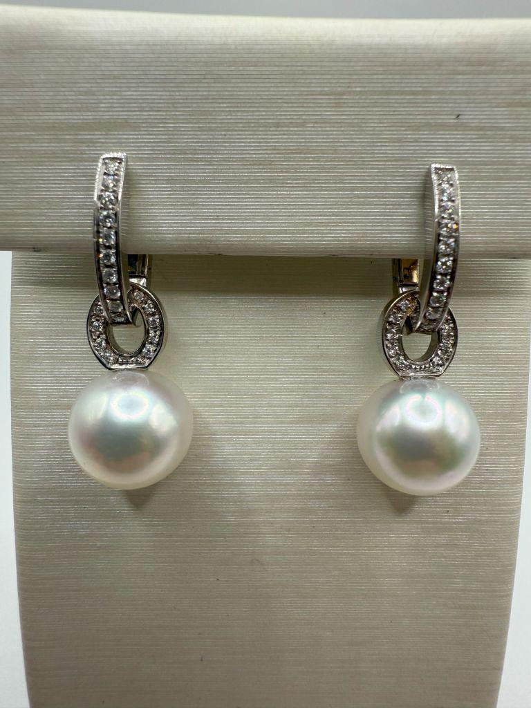 The Utopia Gallery Earrings are a luxurious and timeless pair of earrings that effortlessly combine classic elegance with contemporary style. Set in 18kt white gold, these earrings feature exquisite 12mm white South Sea pearls, renowned for their