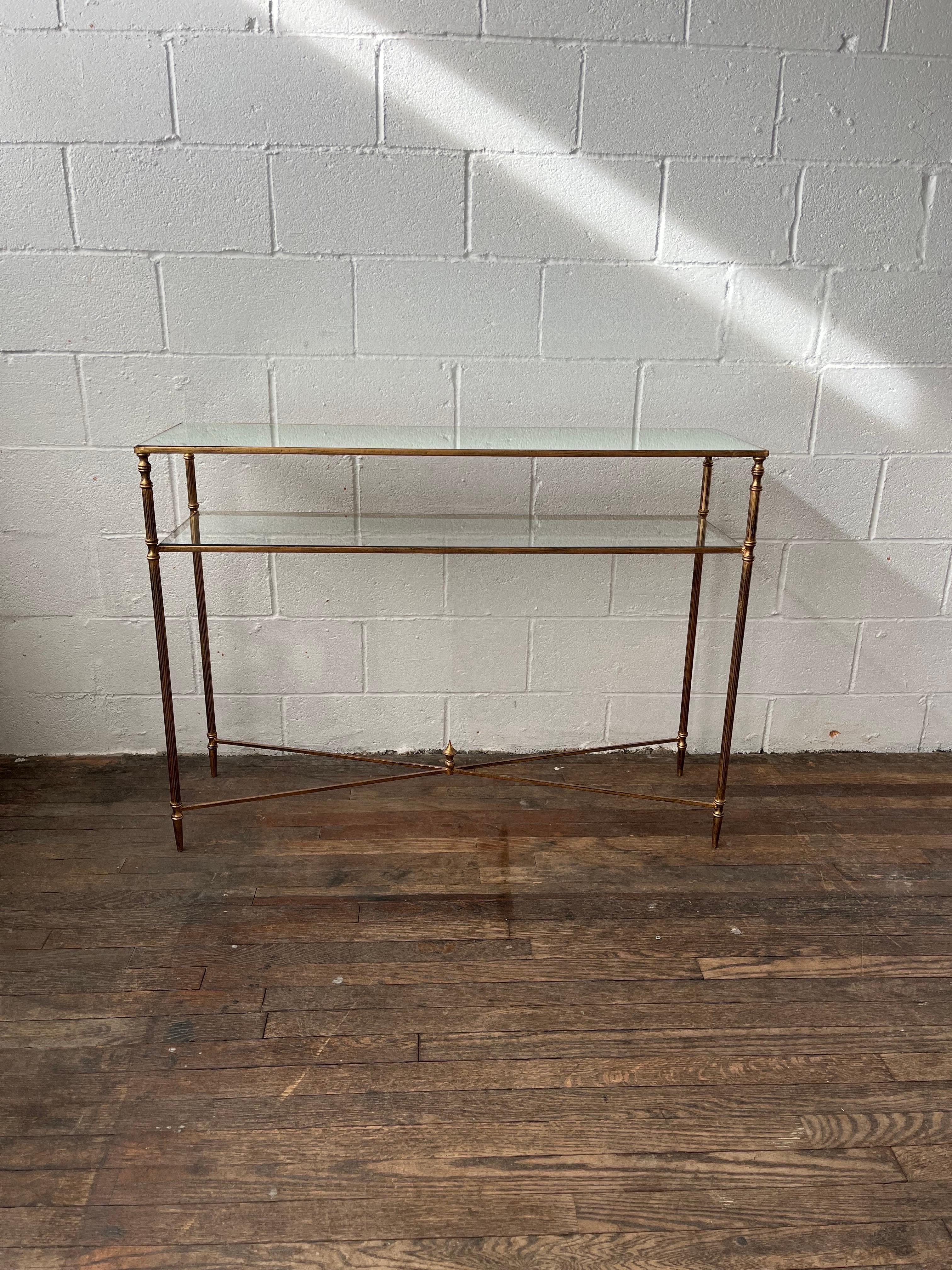 Forged tiered iron frame and iron cross stretchers in antiqued gold leaf. Top is reinforced mirror and gallery shelf is clear tempered glass. Lightweight with style that packs a punch. 
Curbside to NYC/Philly $300