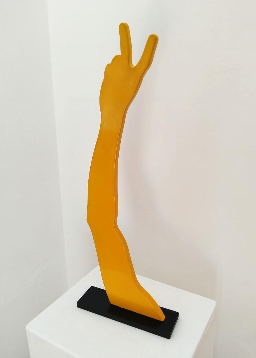 A limited edition, yellow powder coated mild steel sculpture on a black steel base. The sculpture is typical to Uwe Pfaff's tongue in cheek approach, depicting a human arm showing a peace sign. Edition 1/5. Available in different colours on request.