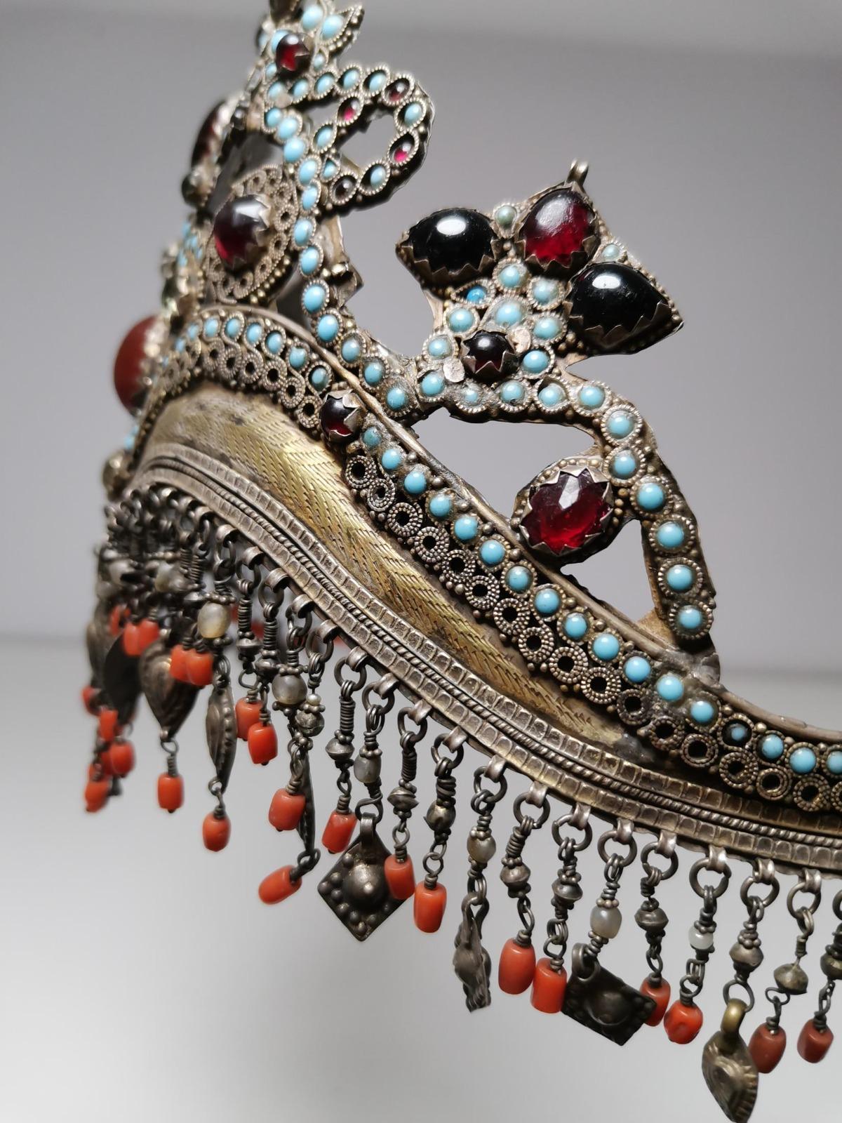Uzbekistan, Tajikistan: a rare, old ‘bridal crown’ made of silver, gilded in parts, with turquoise coloured ornamental stones, glass, coral, and many pendants.
Uzbek and Tajik women wore these ‘bridal crowns’ for the first time at their weddings