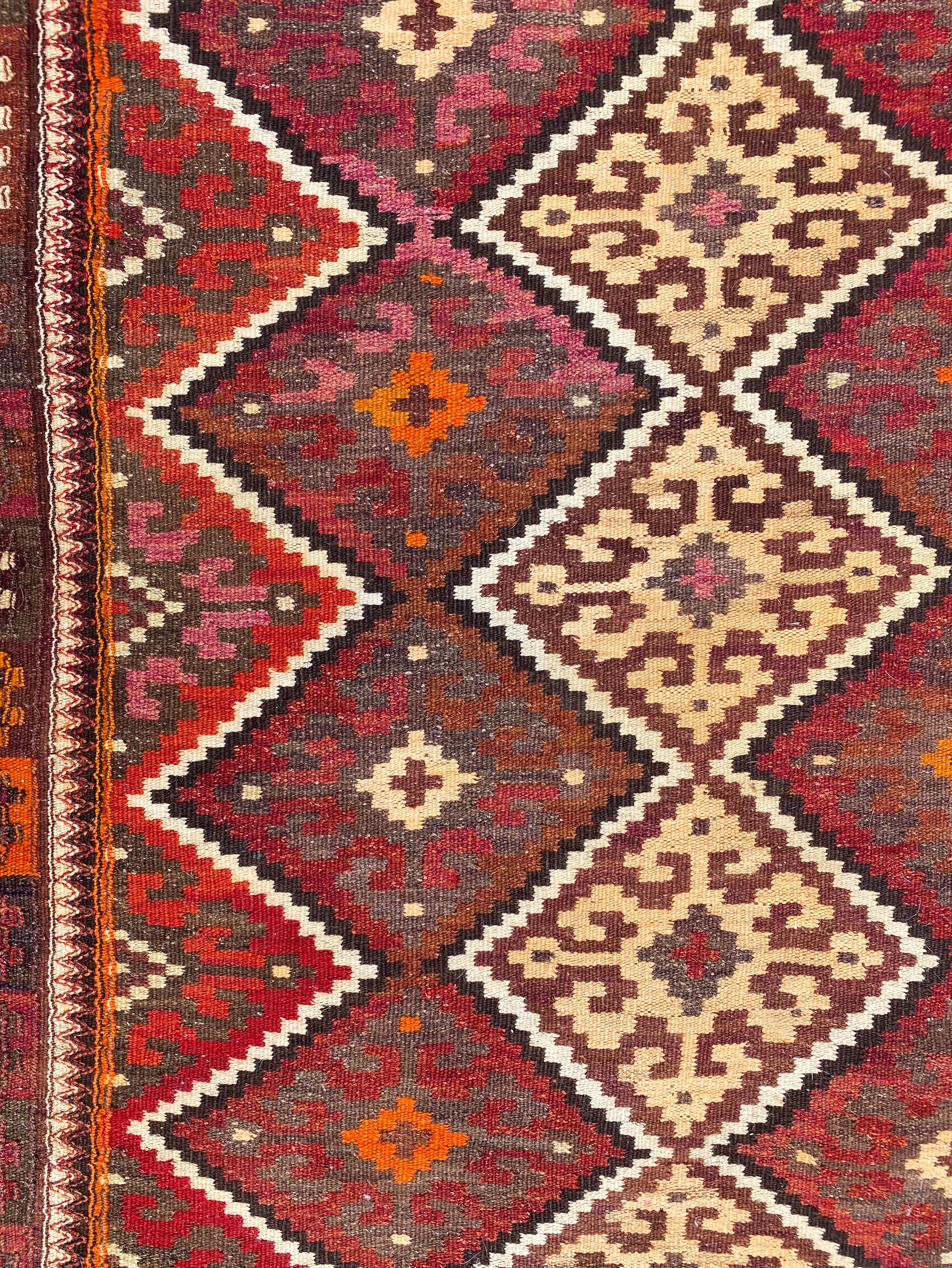 This Antique Uzbekistan Tartari Kilim was crafted from the prolific and diverse Uzbek weavers of Sar-i-Pul. It was crafted using a distinct weave double-interlock technique and employs a grid pattern of diamonds shapes that contain eight pointed