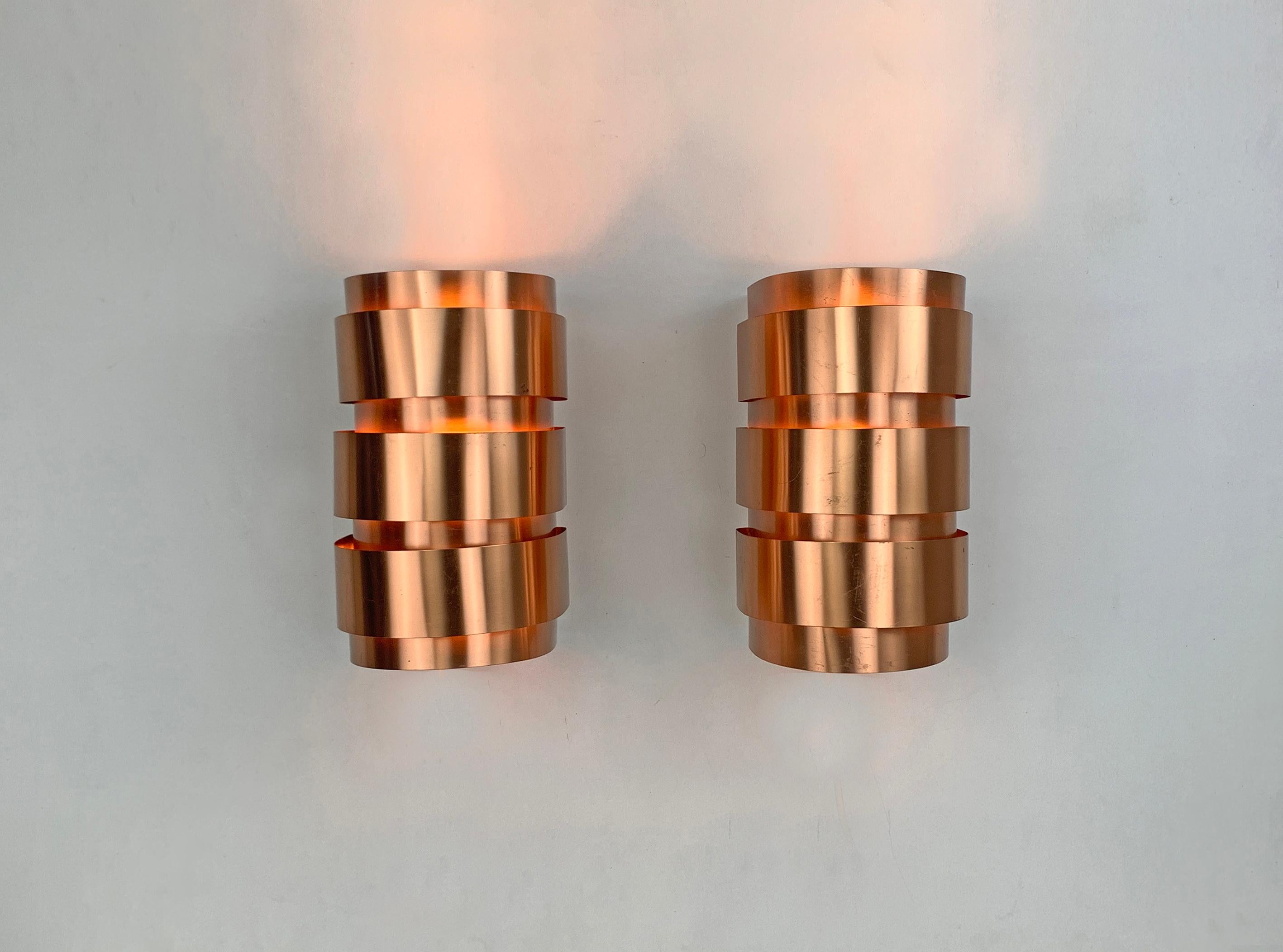 Pair of Scandinavian V-155 wall-lamps in copper finish.
Design by Hans-Agne Jakobsson.
Manufactured by AB Markaryd in Sweden, both retain their original sticker.

Very nice, iconic model. Gives great light effects on the wall.
Patina conform to