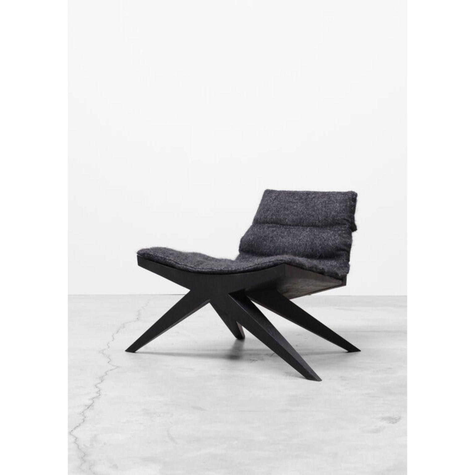 V-easy chair in iroko wood by Arno Declercq
Dimensions: W 100 x D 70 x H 70 cm 
Materials: Burned and waxed iroko wood

Cushion made in mohair by Pierre Frey more fabrics available and price on request. 

Arno Declercq
Belgian designer and