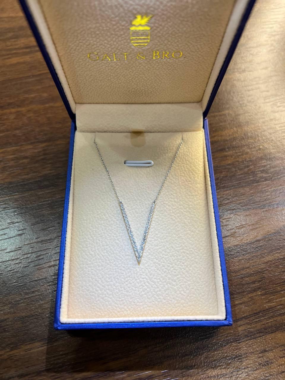 Questo splendido pezzo presenta un design elegante e minimalista con un pendente a forma di V tempestato di diamanti scintillanti. Il ciondolo è sospeso a una delicata catenina, creando un look sofisticato e moderno. Questa collana in oro bianco 18K
