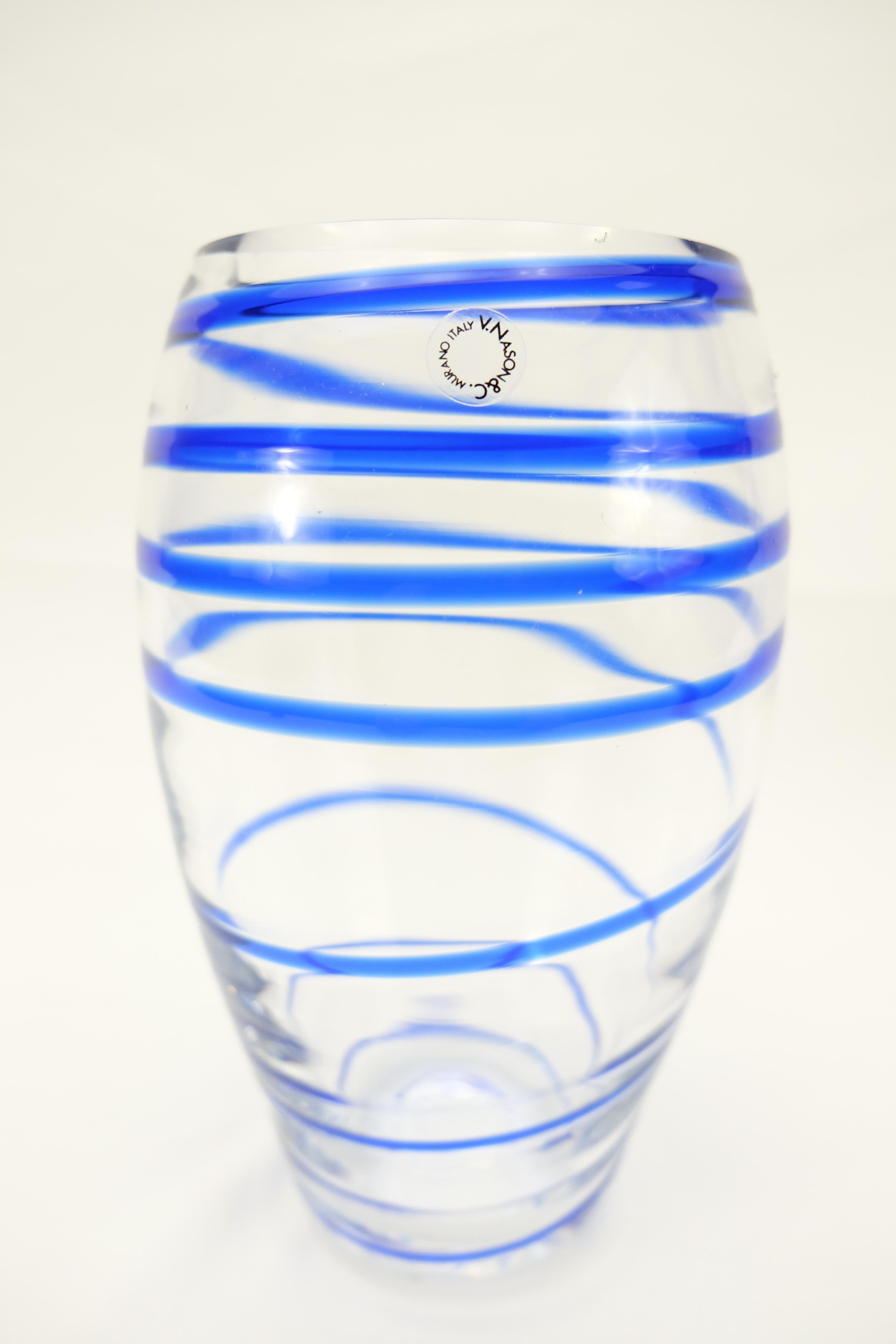 Offered for sale is an Italian blue spiral stripe Murano glass vase by V. Nason & C. This mouth-blown glass vase is created in a transparent and blue spiral color and retains the original sticker label from the maker. Vincenzo Nason established his