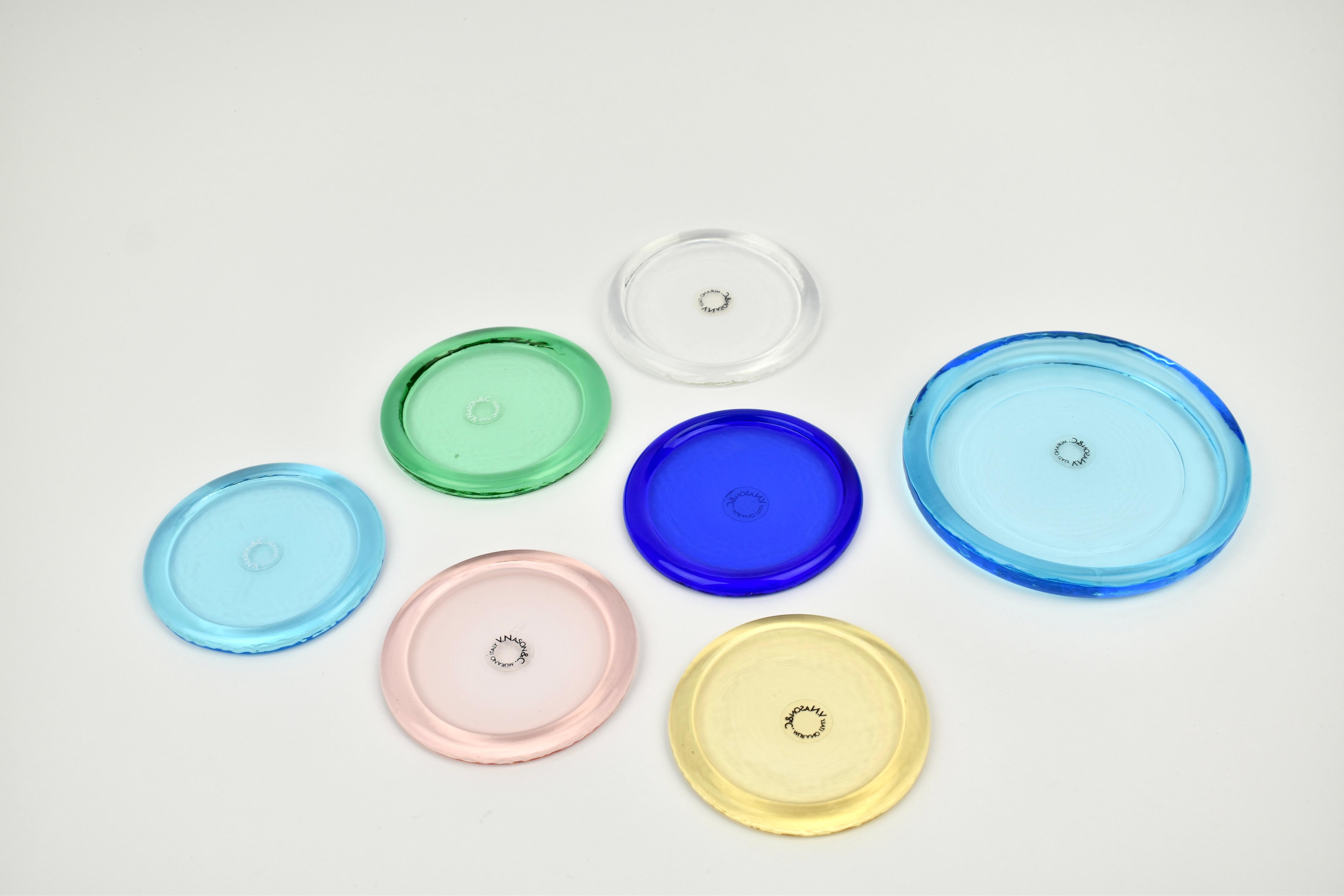 Elegantes und seltenes Set von sieben bunten Murano-Glasuntersetzern von V. Nason & C., Italien, ca. 1980er Jahre. 6 normale Untersetzer und ein größerer, der für eine Weinflasche, eine Teekanne etc. verwendet werden kann. Jeder Untersetzer spiegelt
