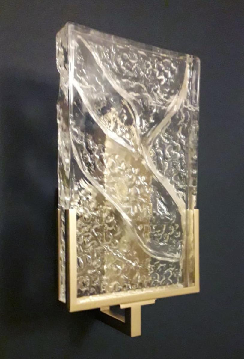Aplique italiano con difusor rectangular de cristal de Murano de textura transparente montado sobre una estructura metálica con acabado en latón envejecido / Fabricado en Italia
Medidas: Alto 14 pulgadas, ancho 6 pulgadas, fondo 5,5 pulgadas 
1 luz