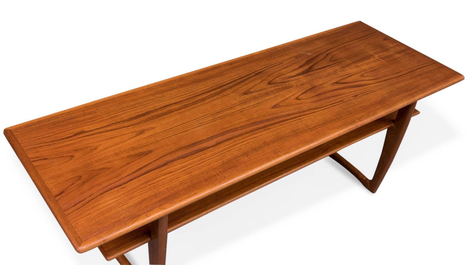 Teak coffee table with rectangular tray, low shelf and V-shaped legs. Danish furniture manufacturer. Produced in 1950s-1960s.
Measures: H. 54 x 151 x 53 cm.