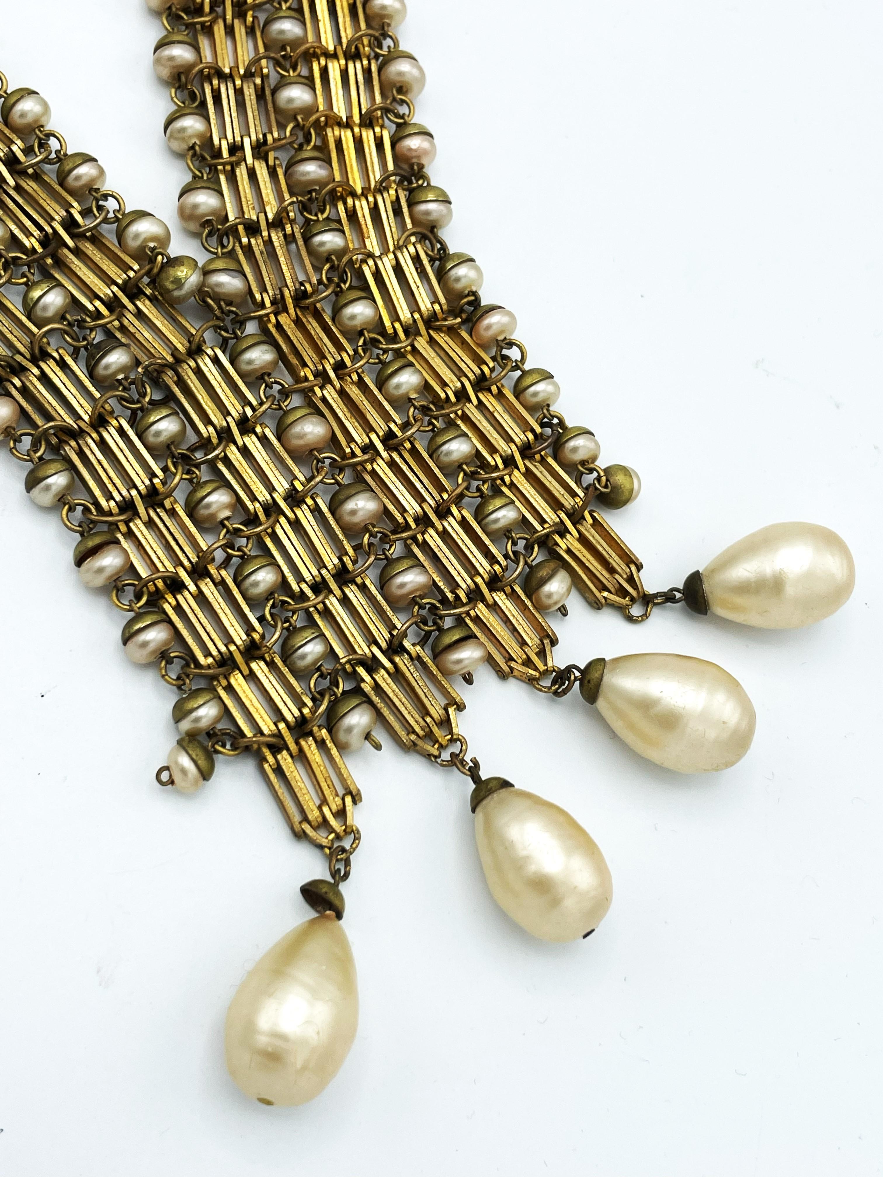 Collier en forme de V, fabriqué en France au début des années 1940, plaqué or et belles perles faites à la main.
2 brins individuels plaqués or de 3,5 cm de large chacun, bordés de petites perles. 
Les 6 cm inférieurs sont reliés entre eux, ce qui