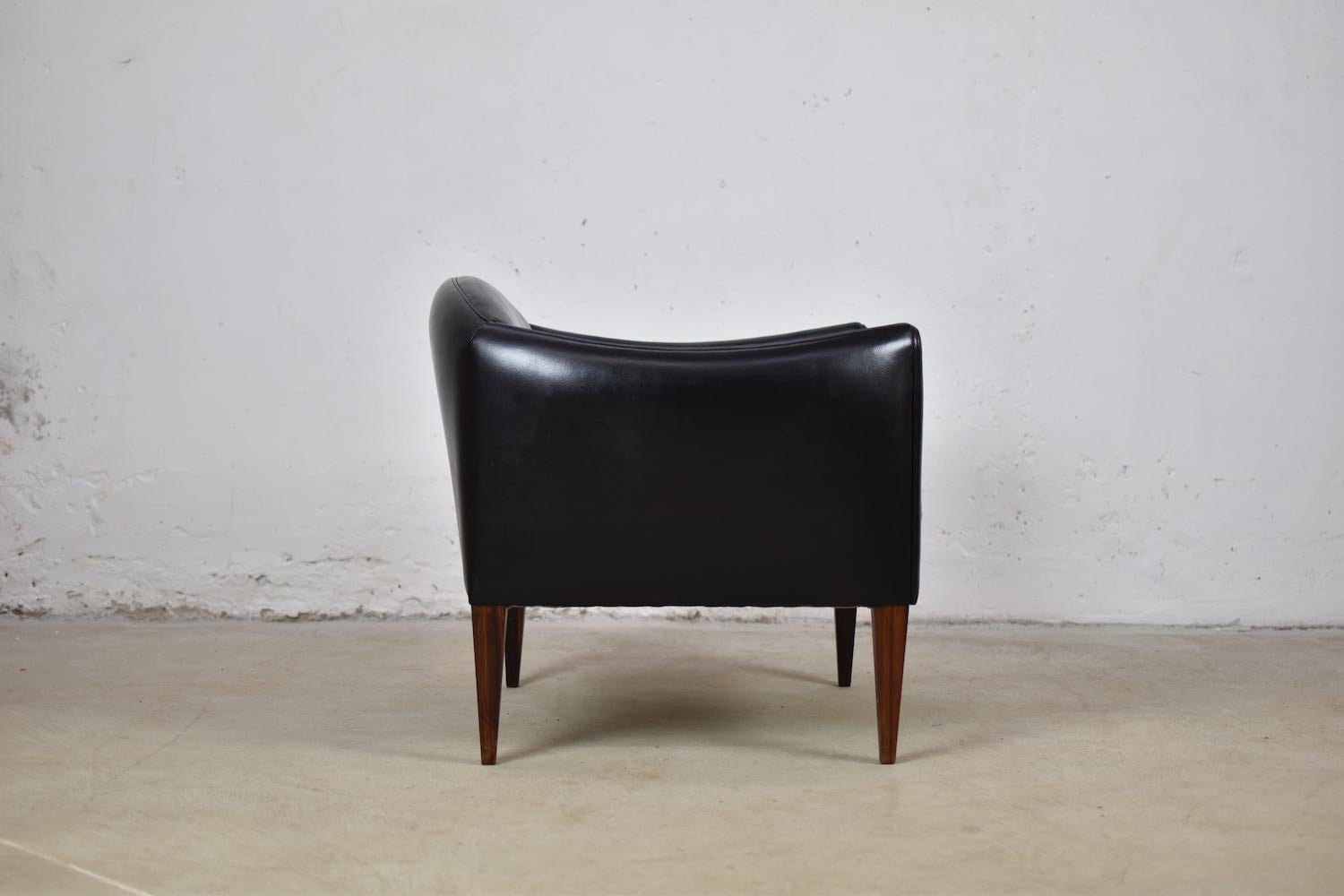 Lovely V12 easy chair by Illum Wikkelsø for Søren Willadsen Møbelfabrik, Denmark, 1960s. This elegant side chair features a black leather upholstery and marvelous shaped rosewood legs. Very good original condition.