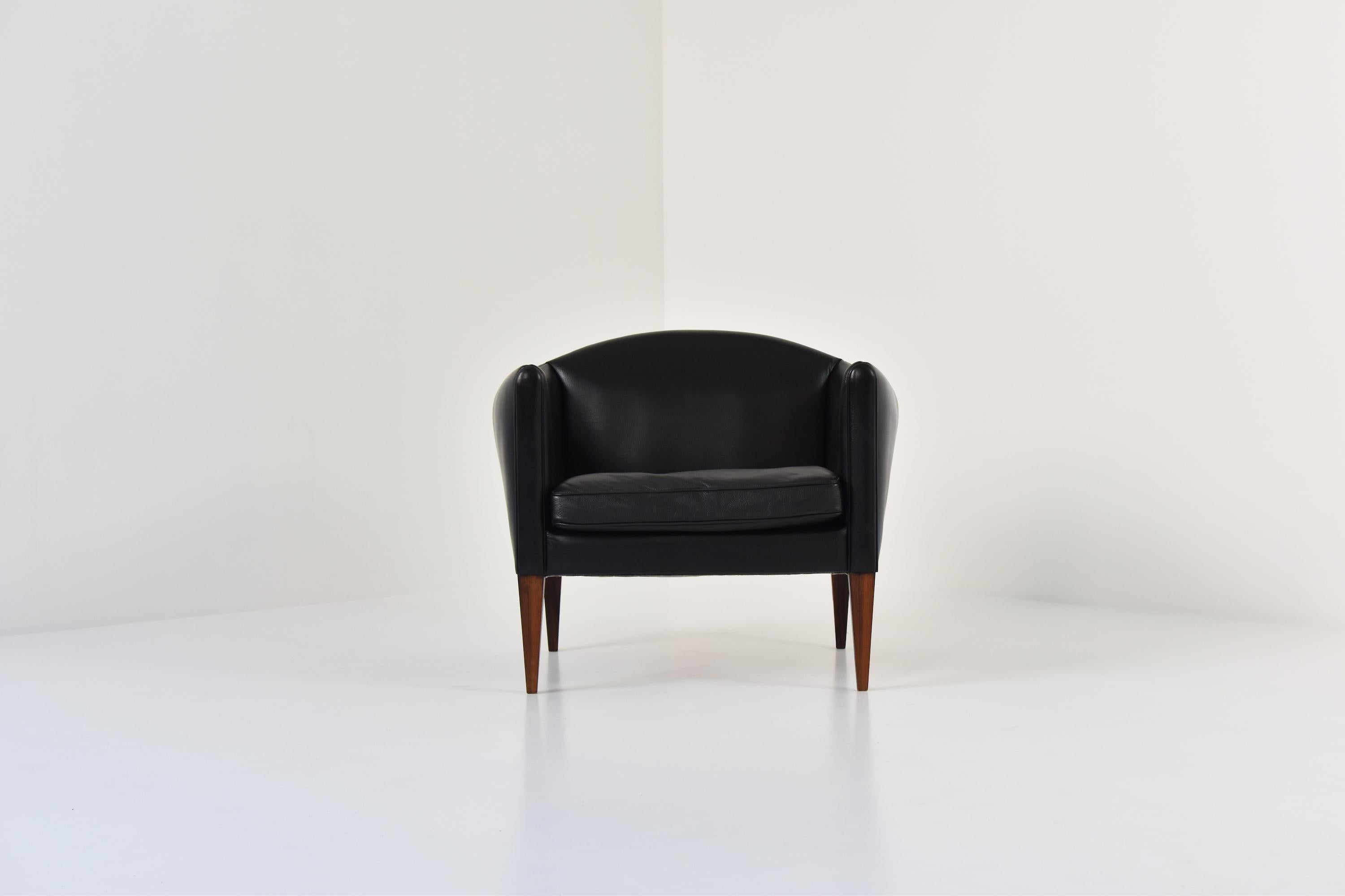 Lovely V12 easy chair by Illum Wikkelsø for Søren Willadsen Møbelfabrik, Denmark, 1960s. This elegant side chair features a black leather upholstery and marvelous shaped rosewood legs. Very good original condition.